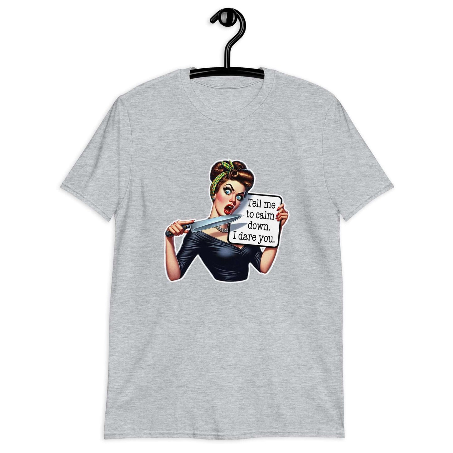 Light grey t-shirt displayed on a hanger. The t-shirt has a graphic of an angry looking retro woman holding a knife and a sign. The sign says Tell me to calm down I dare you. The graphic is printed on the front of the shirt.