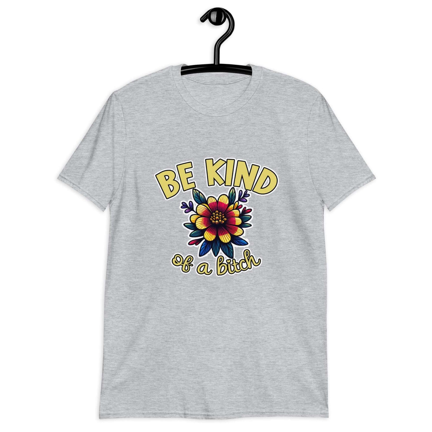 Light grey t-shirt with an image of a flower and the words Be kind above the flower in yellow bold block font. The words Of a bitch are smaller in script font under the flower. The design is printed on the front of the shirt.