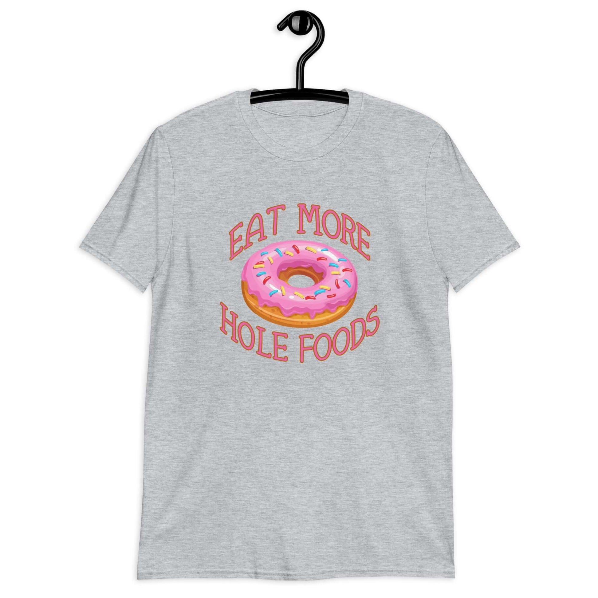 Sport grey t-shirt that has an image of a donut with pink icing and sprinkles and Eat more hole foods printed on the front.