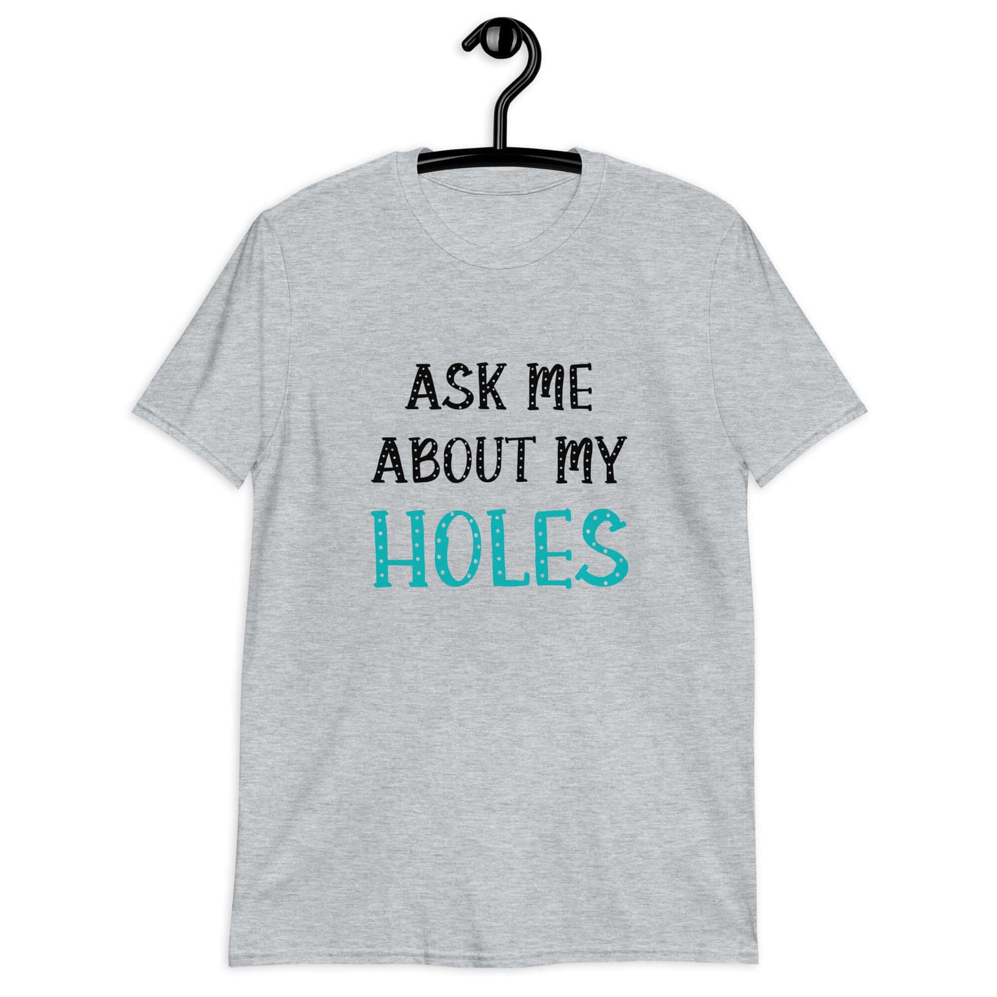 Sport grey t-shirt with the words Ask me about my holes printed on the front. The word holes in turquoise color and the rest of the text is black.