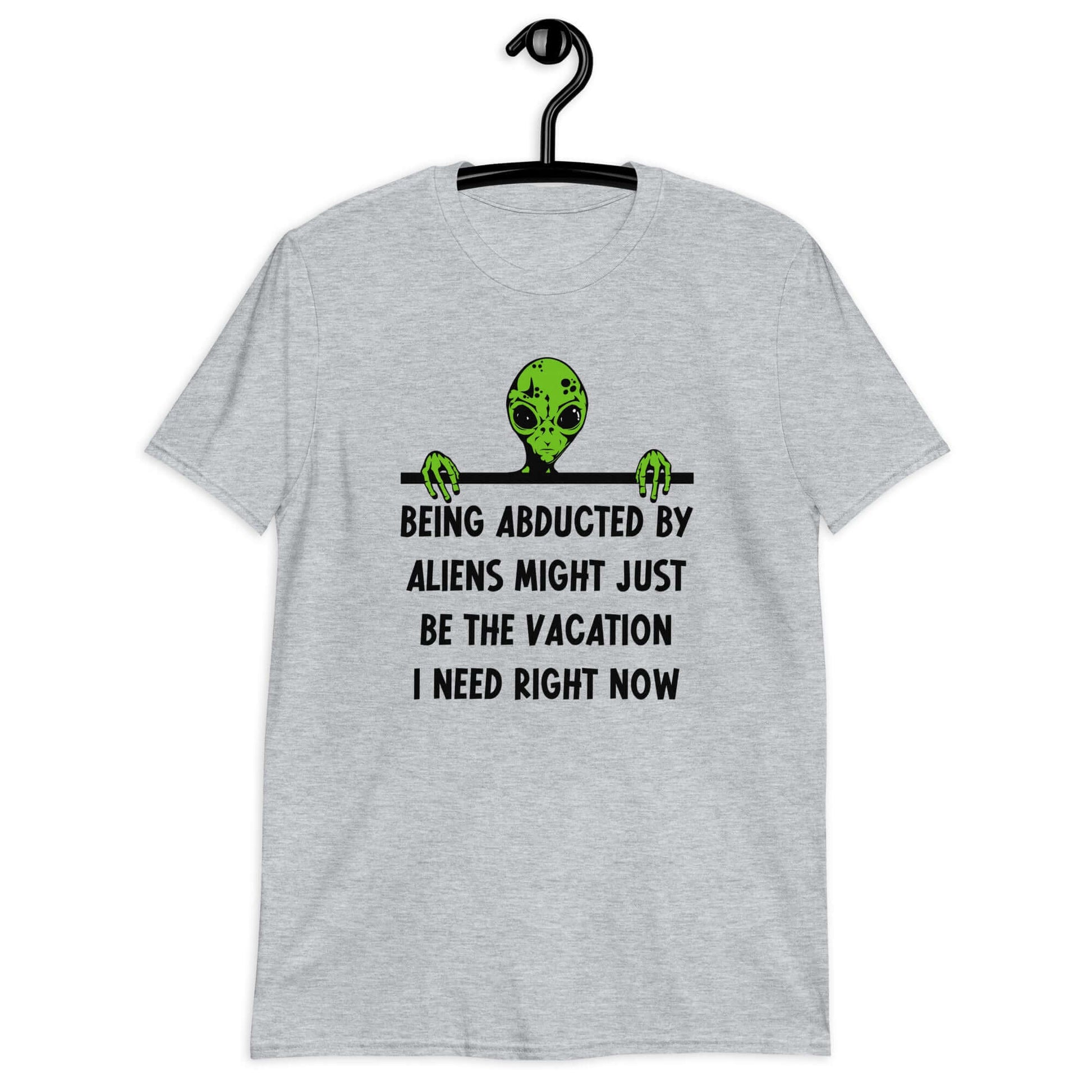 Sport grey t-shirt with an image of a green alien and the phrase Being abducted by aliens might just be the vacation I need right now printed on the front of the shirt.