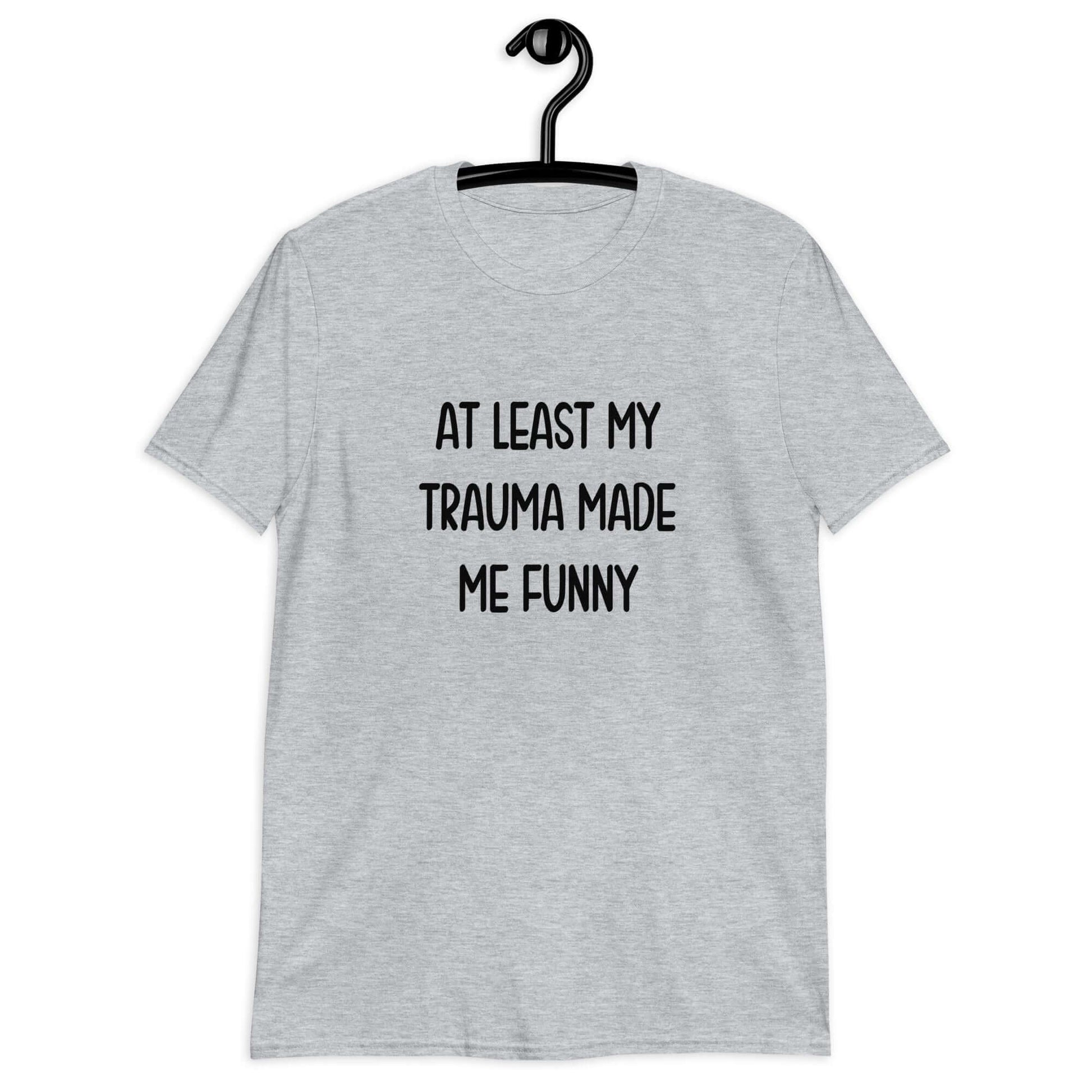Sport grey t-shirt with the words At least my trauma made me funny printed on the front.