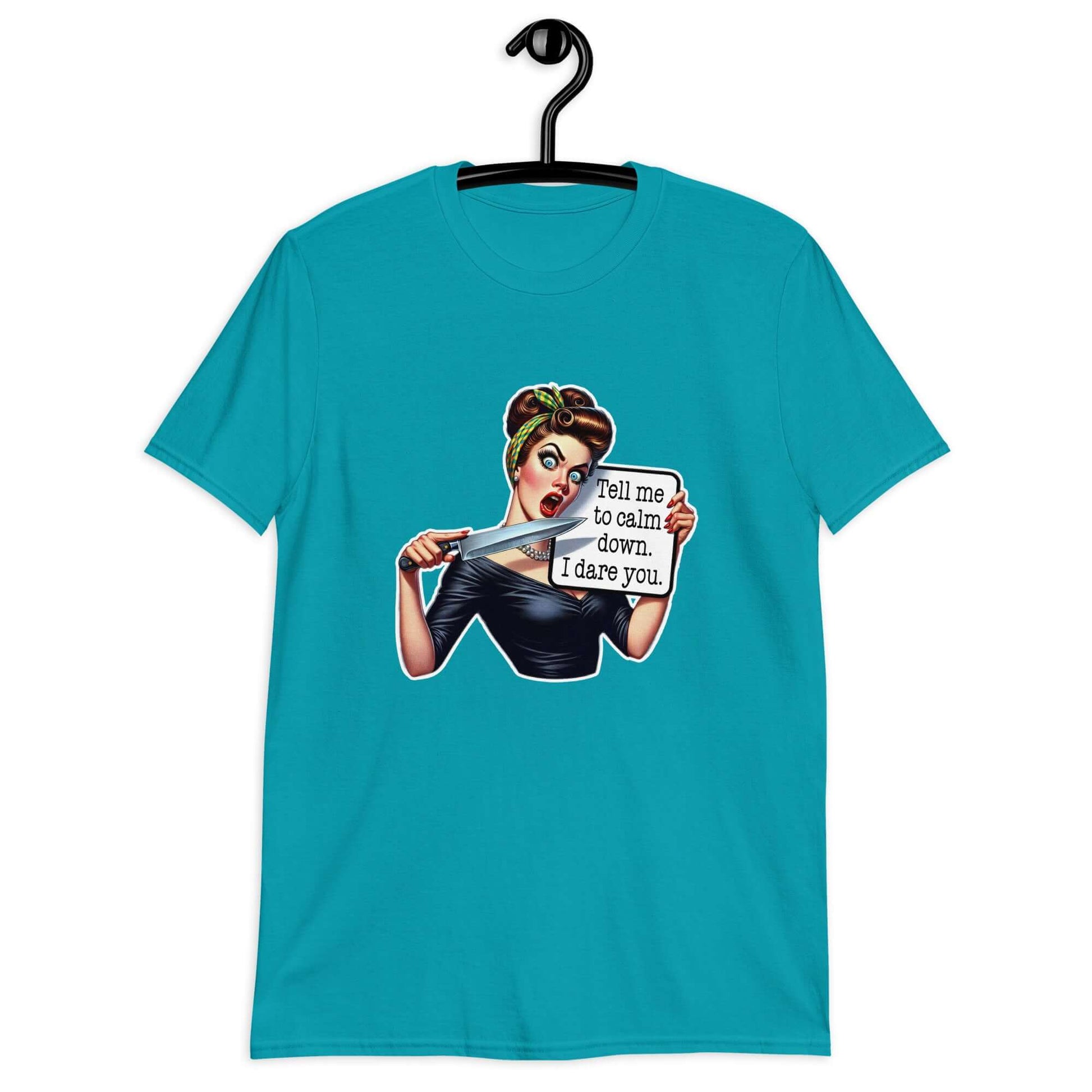 Tropical blue t-shirt displayed on a hanger. The t-shirt has a graphic of an angry looking retro woman holding a knife and a sign. The sign says Tell me to calm down I dare you. The graphic is printed on the front of the shirt.