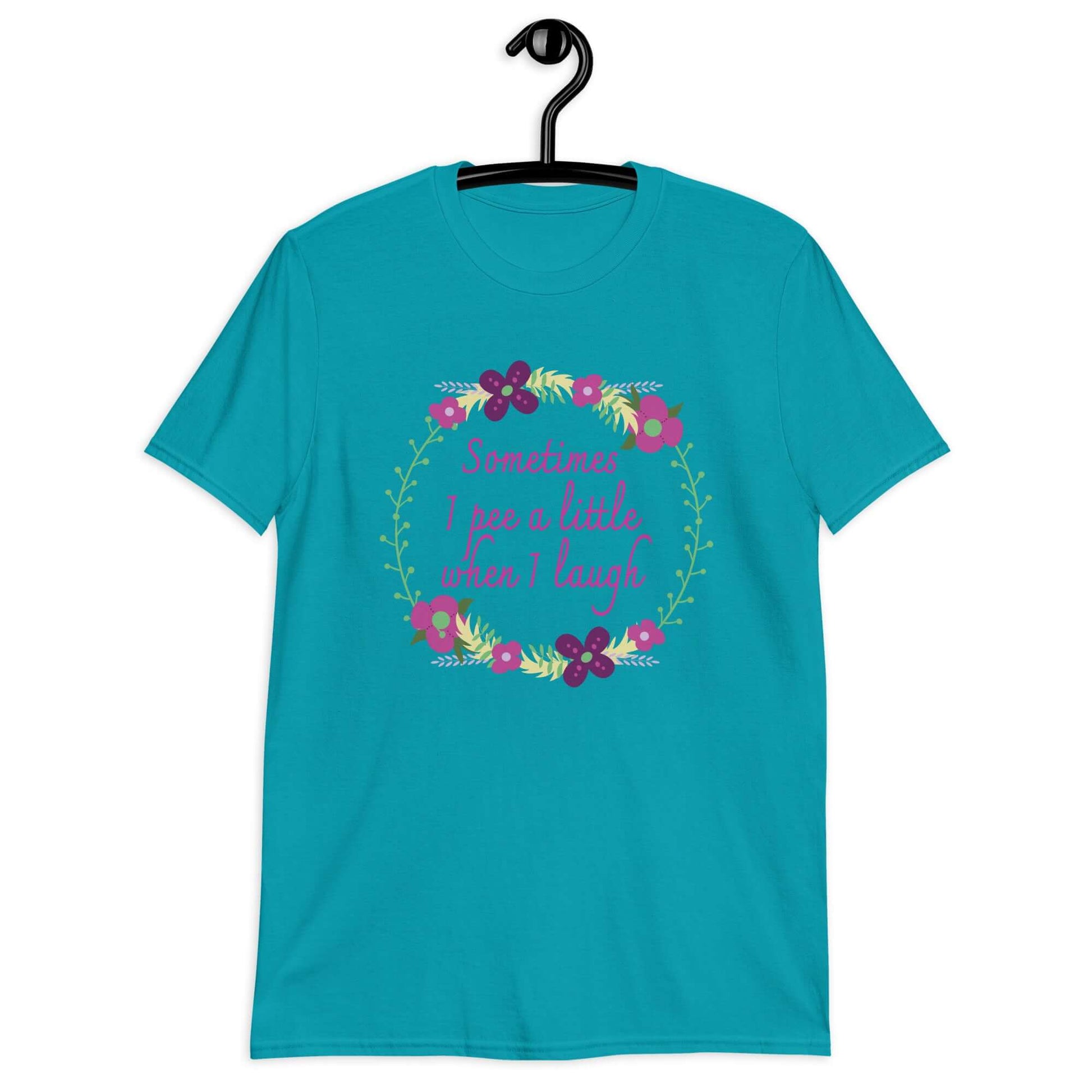 Tropical  blue t-shirt that has a minimalistic style line drawing floral wreath with the phrase Sometimes I pee a little when I laugh printed in the center of the wreath. The graphics are printed on the front of the shirt.