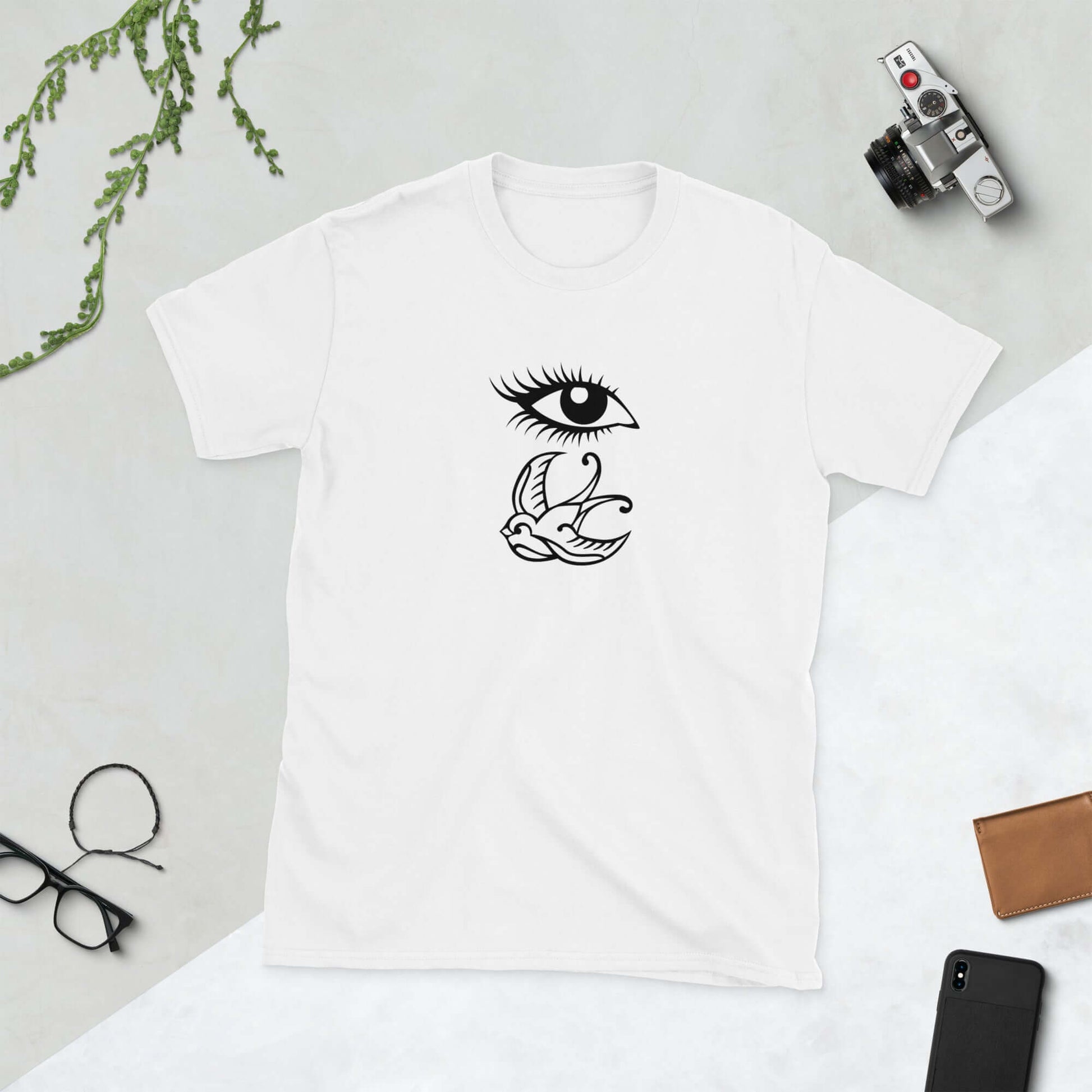 White t-shirt with outline drawing of an eye and a swallow bird printed on the front.