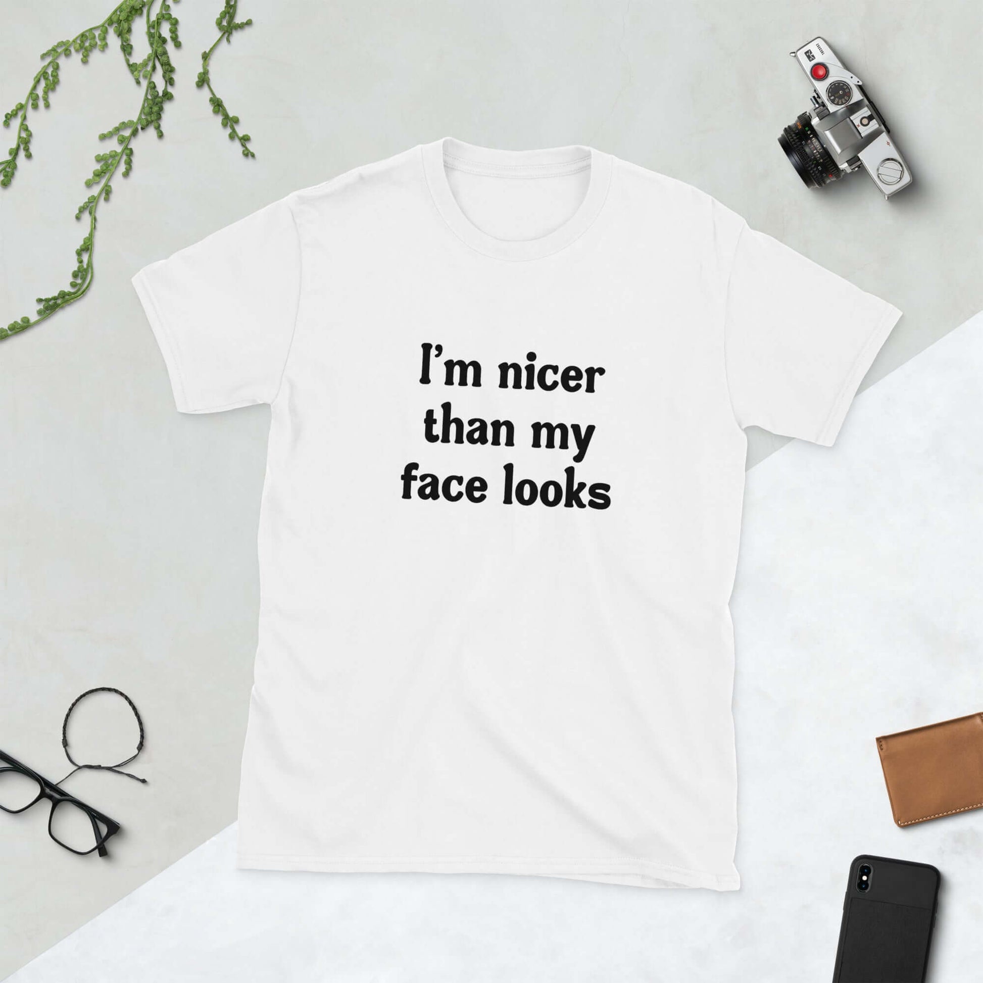White t-shirt that says I'm nicer than my face looks printed on the front.