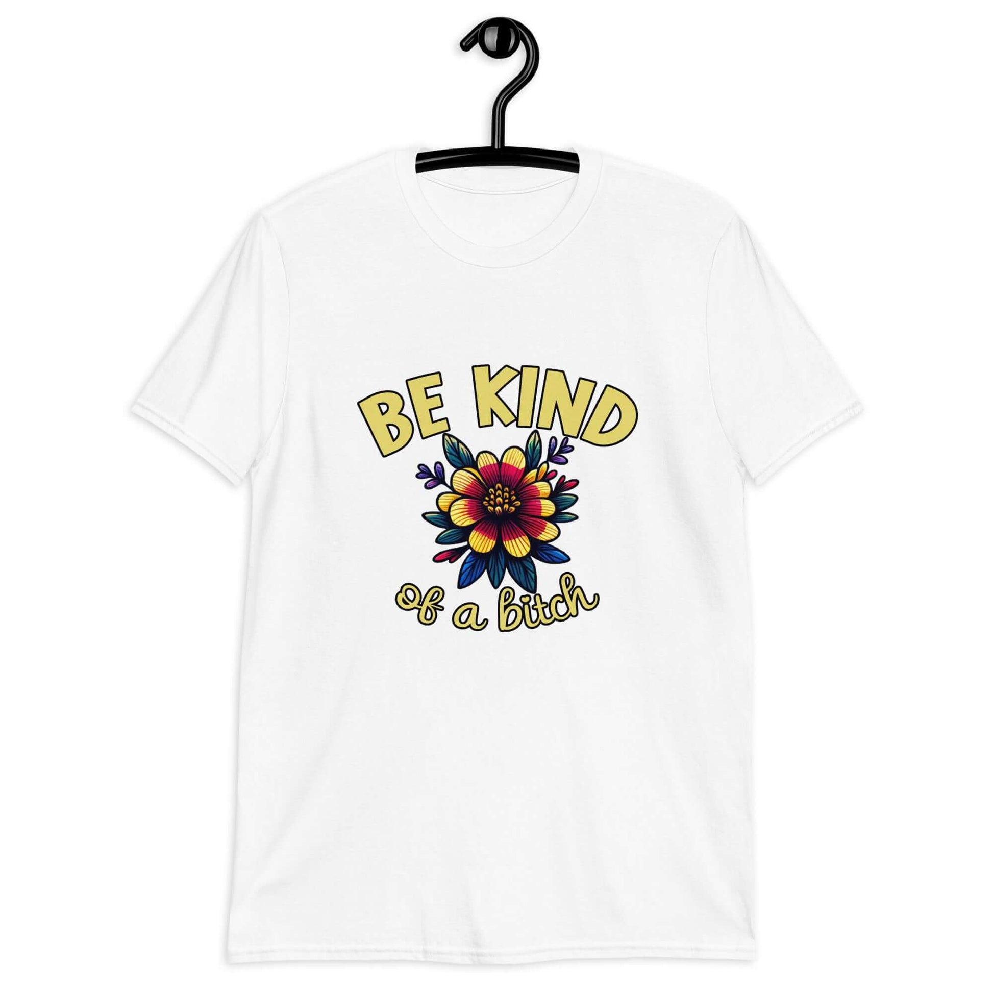 White t-shirt with an image of a flower and the words Be kind above the flower in yellow bold block font. The words Of a bitch are smaller in script font under the flower. The design is printed on the front of the shirt.