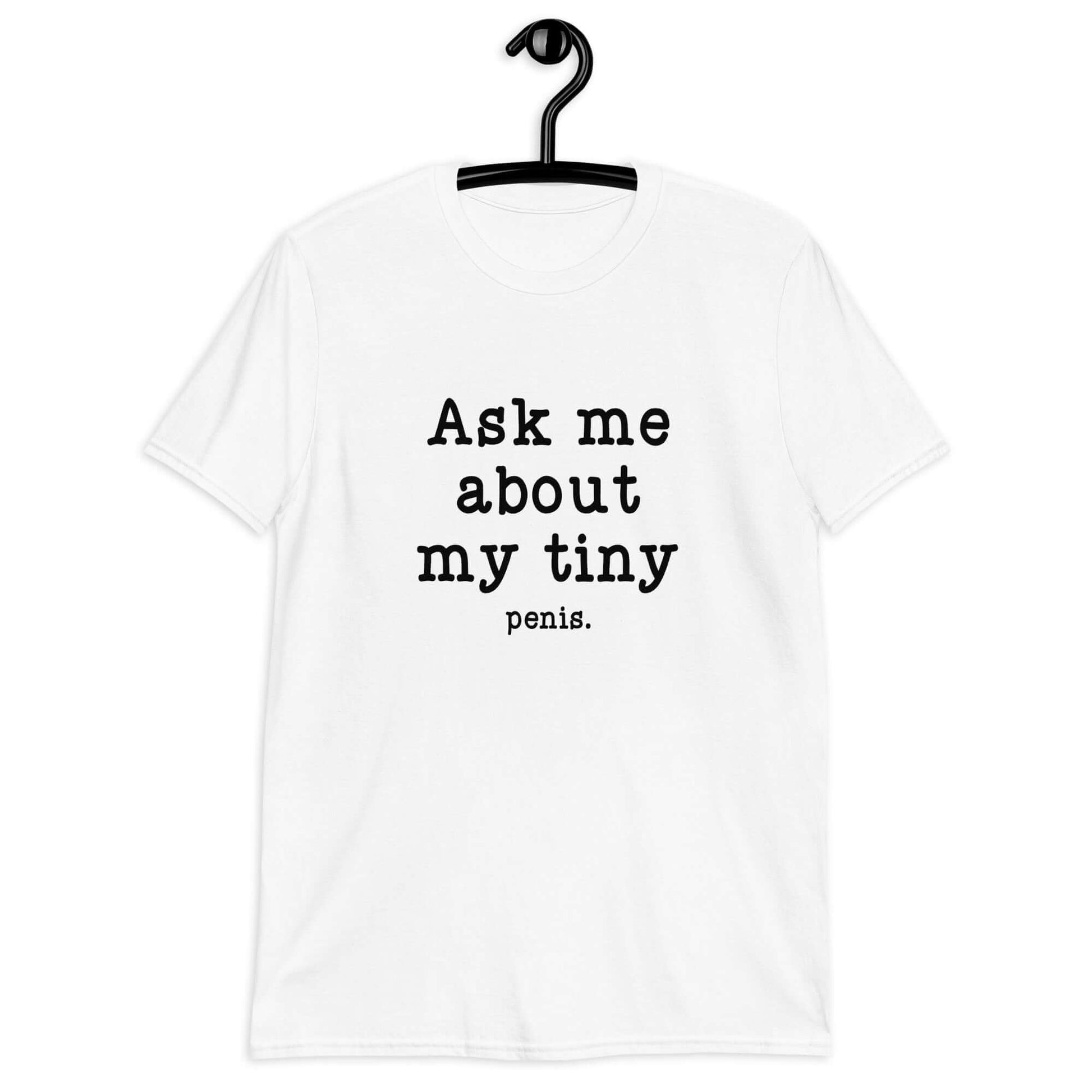 White t-shirt with the phrase Ask me about my tiny penis printed on the front. The word tiny is much smaller than the rest of the text.