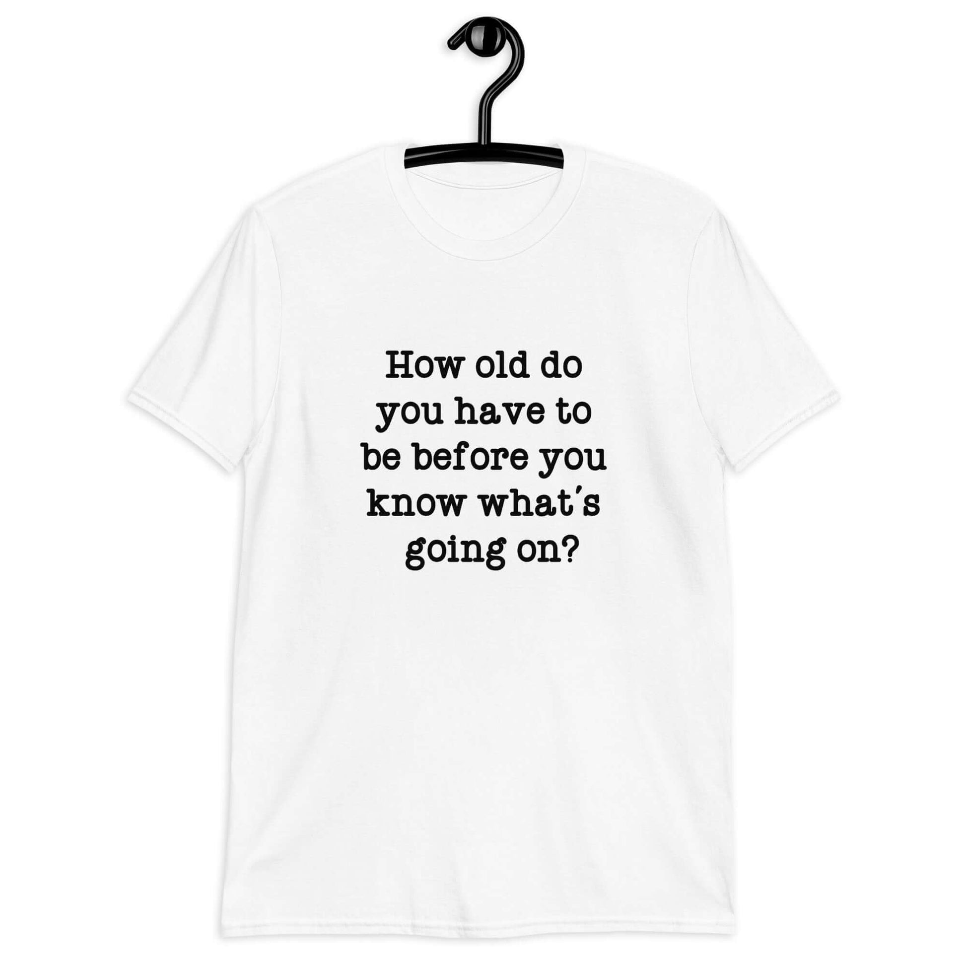 White t-shirt with the phrase How old do you have to be before you know whats going on question mark printed on the front.