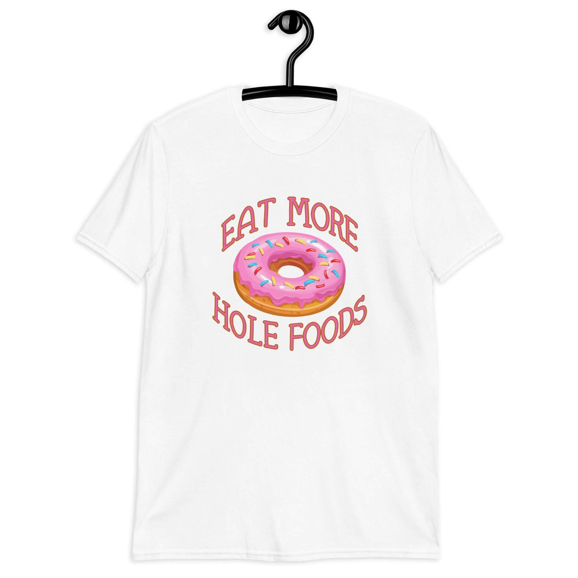 White t-shirt that has an image of a donut with pink icing and sprinkles and Eat more hole foods printed on the front.