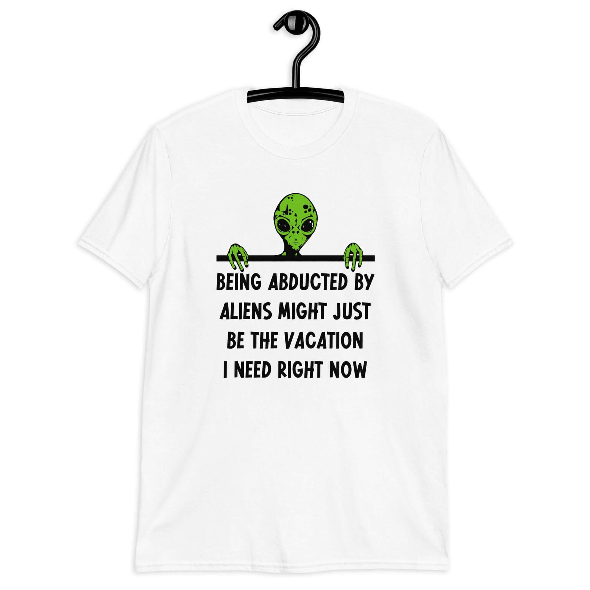 White t-shirt with an image of a green alien and the phrase Being abducted by aliens might just be the vacation I need right now printed on the front of the shirt.