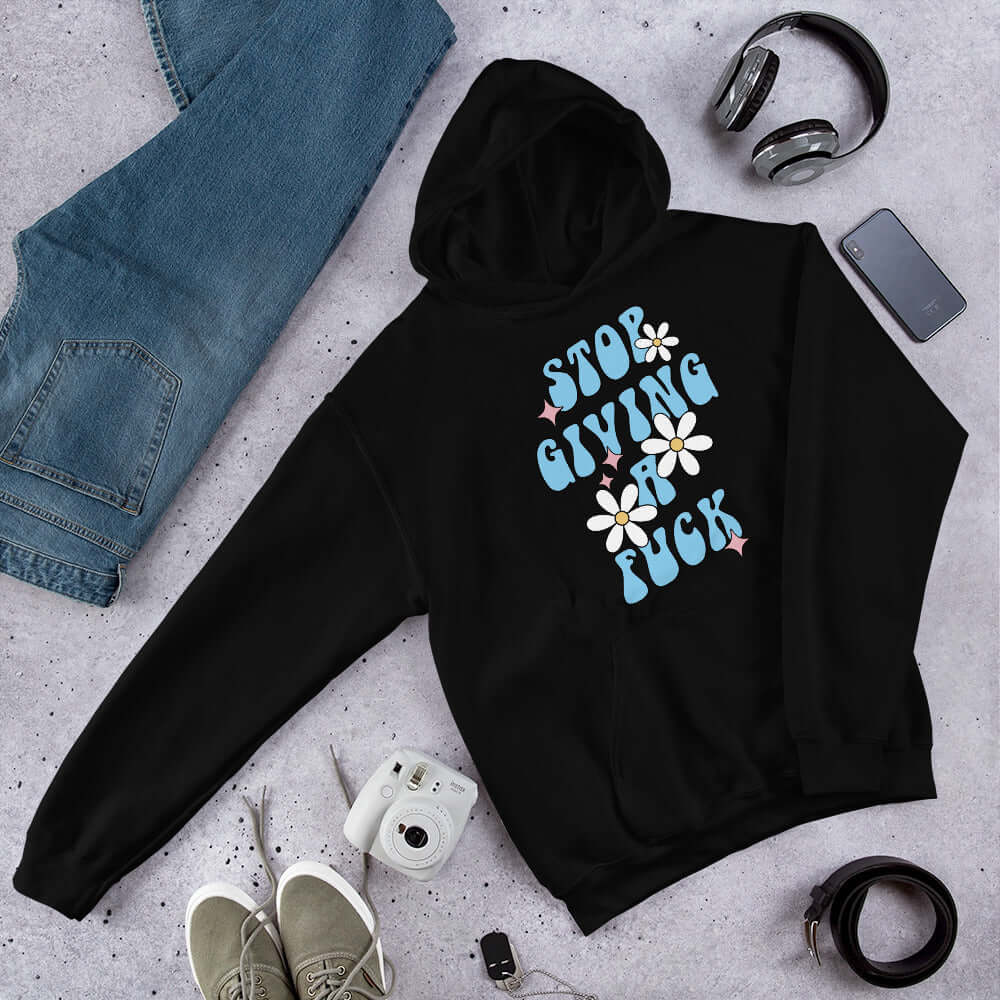 Black hoodie sweatshirt with stop giving a fuck printed on the front.