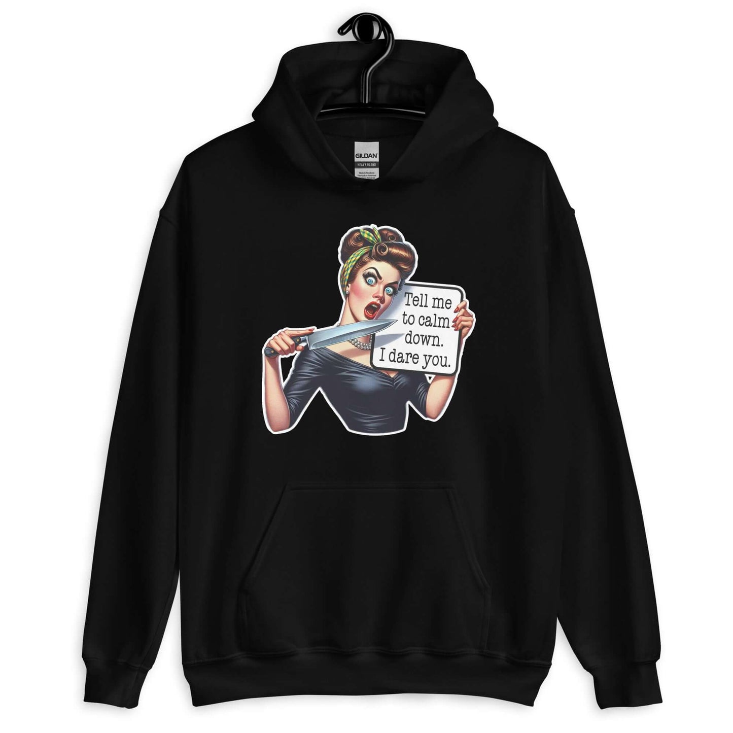 Black hooded sweatshirt displayed on a hanger. The sweatshirt has a graphic of an angry looking retro woman holding a knife and a sign. The sign says Tell me to calm down I dare you. The graphic is printed on the front of the hoodie.