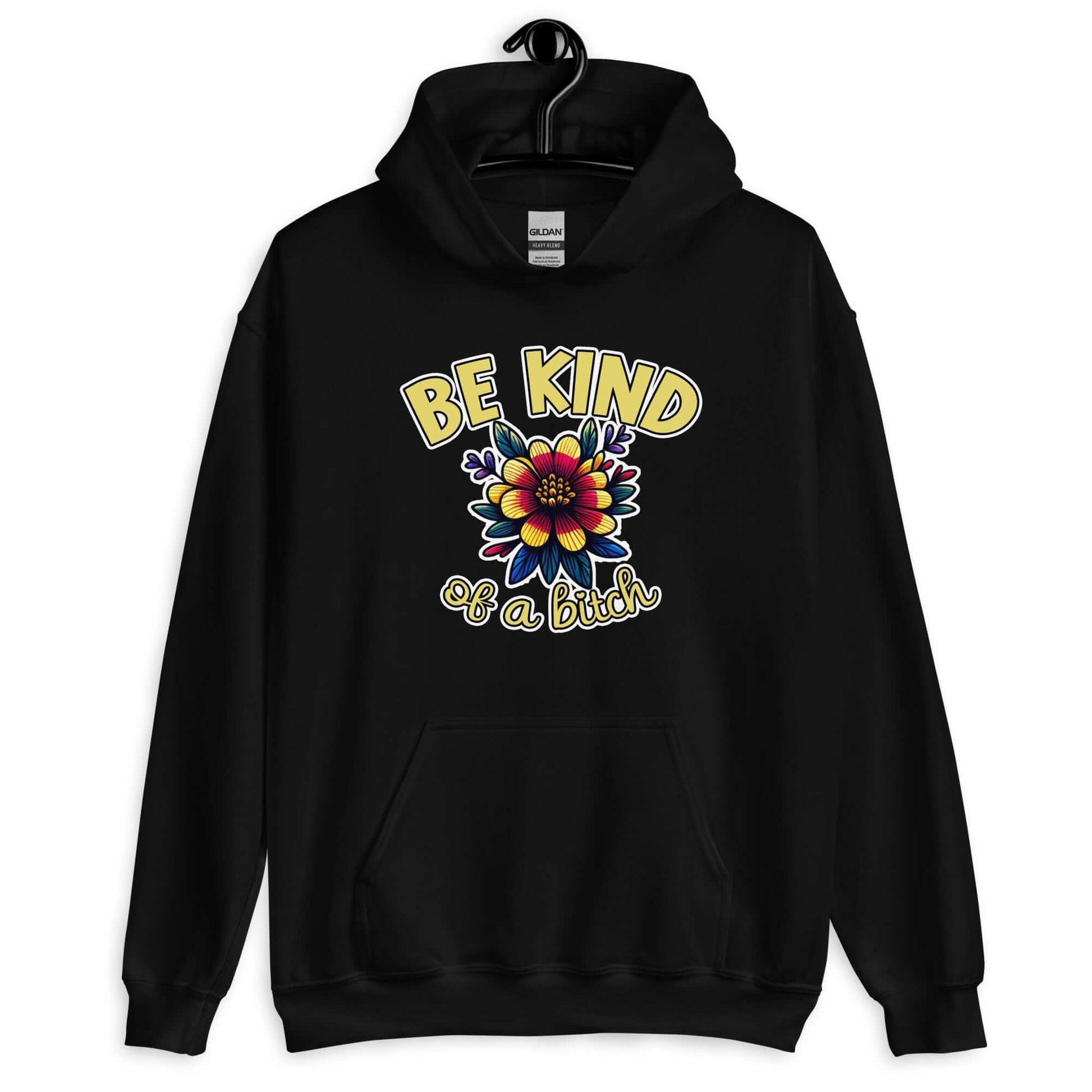 Black hoodie sweatshirt with an image of a flower and the words Be kind above the flower in yellow bold block font. The words Of a bitch are smaller in script font under the flower. The design is printed on the front of the hoodie.