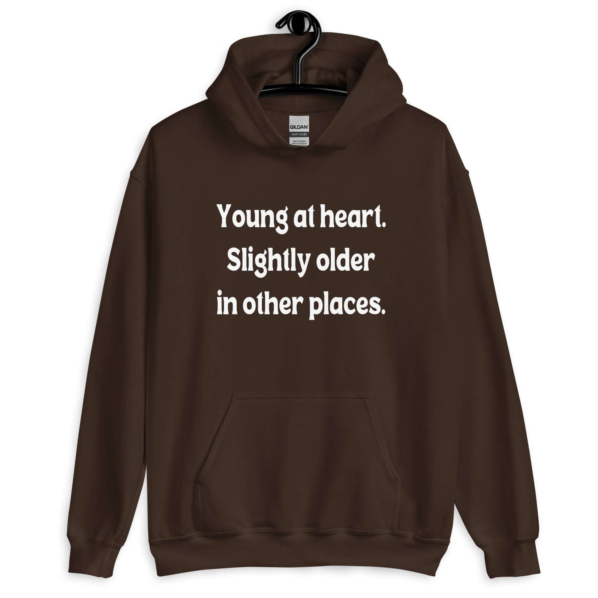 Dark chocolate brown hoodie sweatshirt with the words Young at heart, slightly older in other places printed on the front.