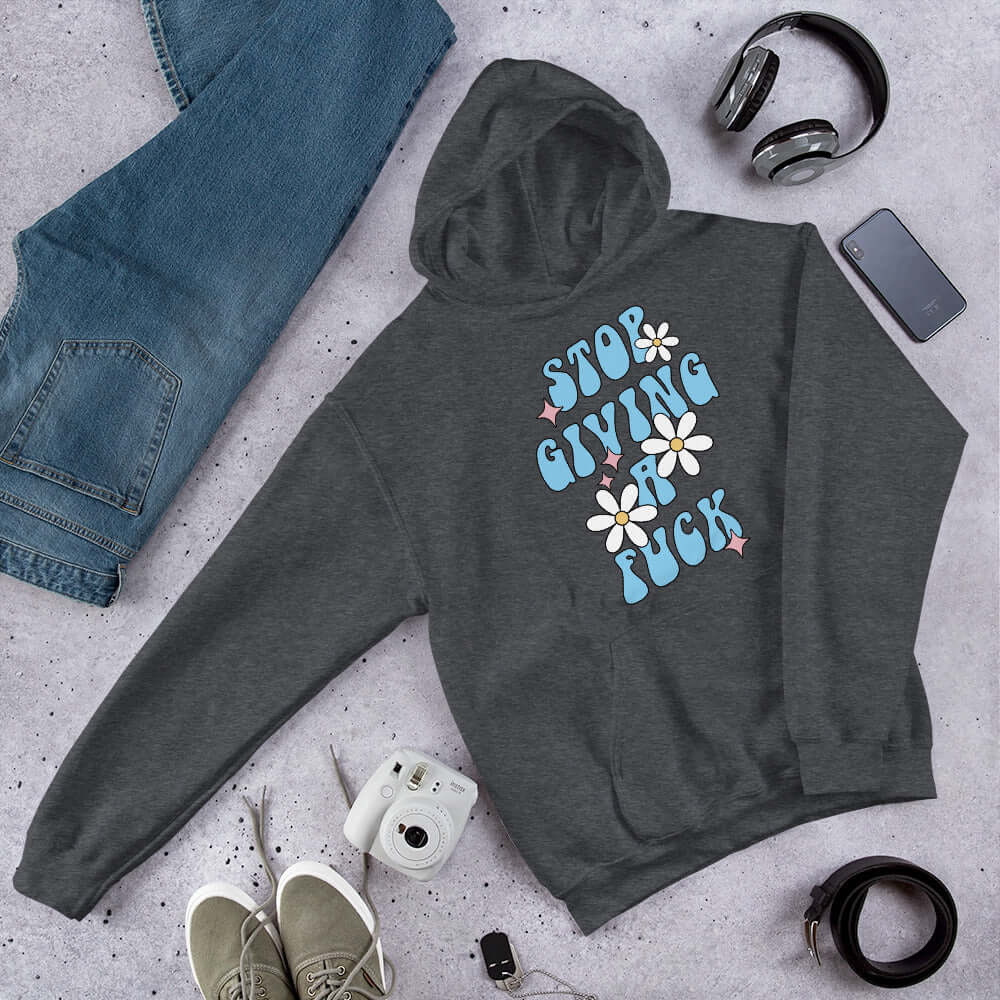 Dark heather hoodie sweatshirt with stop giving a fuck printed on the front.