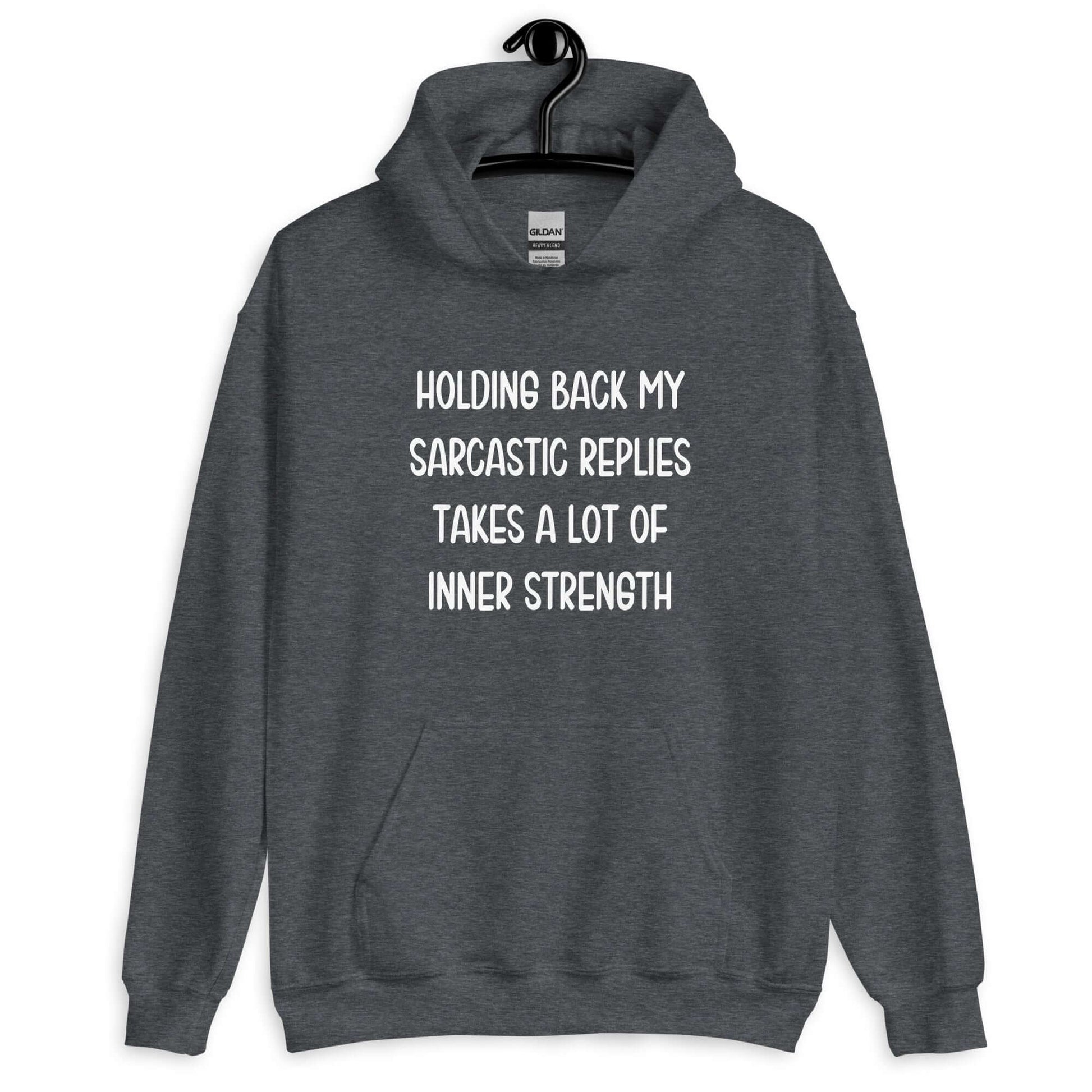 Dark heather grey hoodie sweatshirt with the phrase Holding back my sarcastic replies takes a lot of inner strength printed on the front.