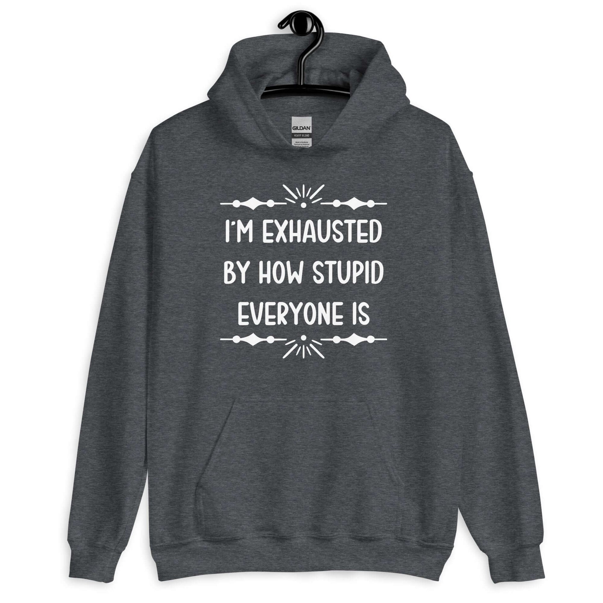 Dark heather grey hoodie sweatshirt with the phrase I'm exhausted by how stupid everyone is. The graphics are printed on the front of the hoodie.