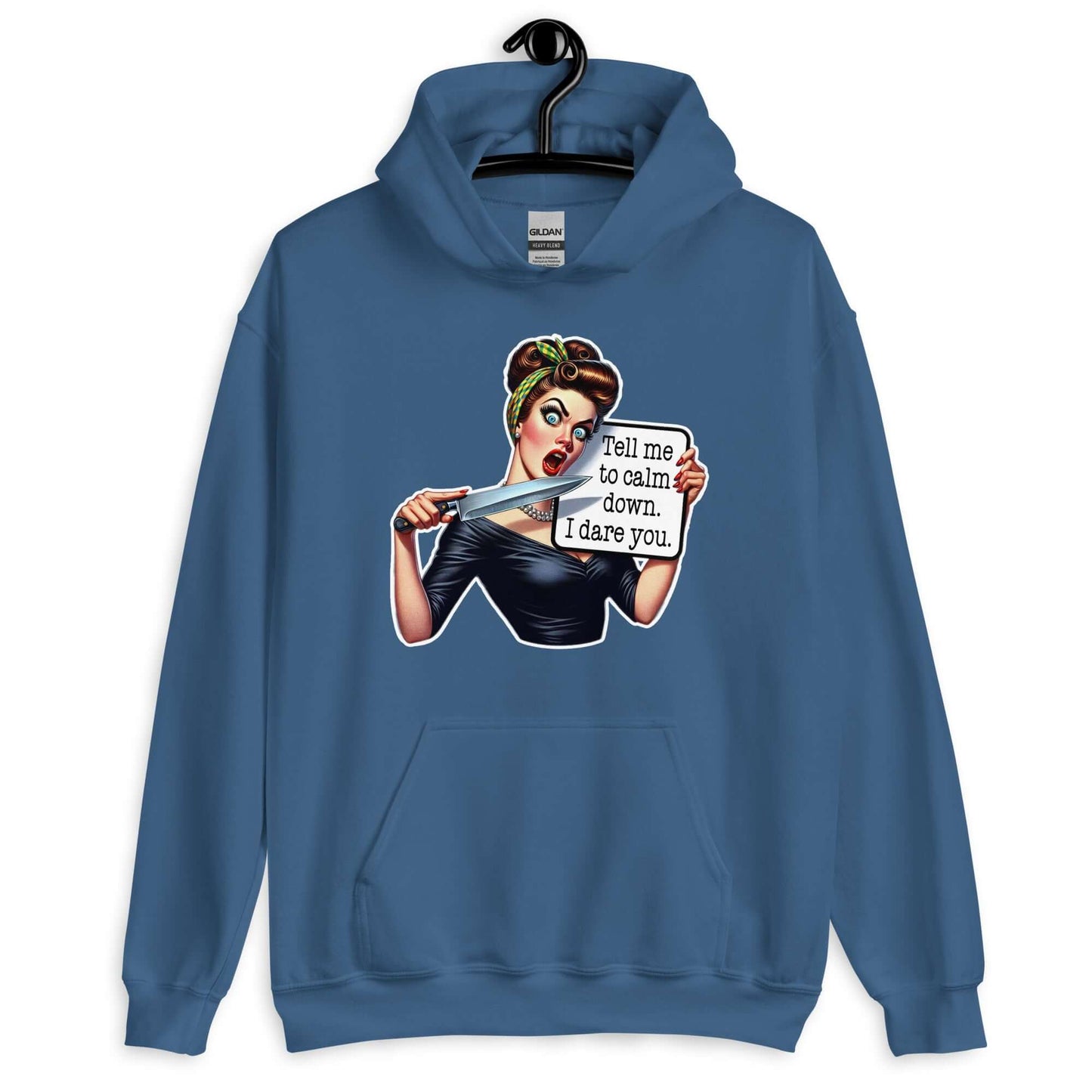 Indigo blue hooded sweatshirt displayed on a hanger. The sweatshirt has a graphic of an angry looking retro woman holding a knife and a sign. The sign says Tell me to calm down I dare you. The graphic is printed on the front of the hoodie.