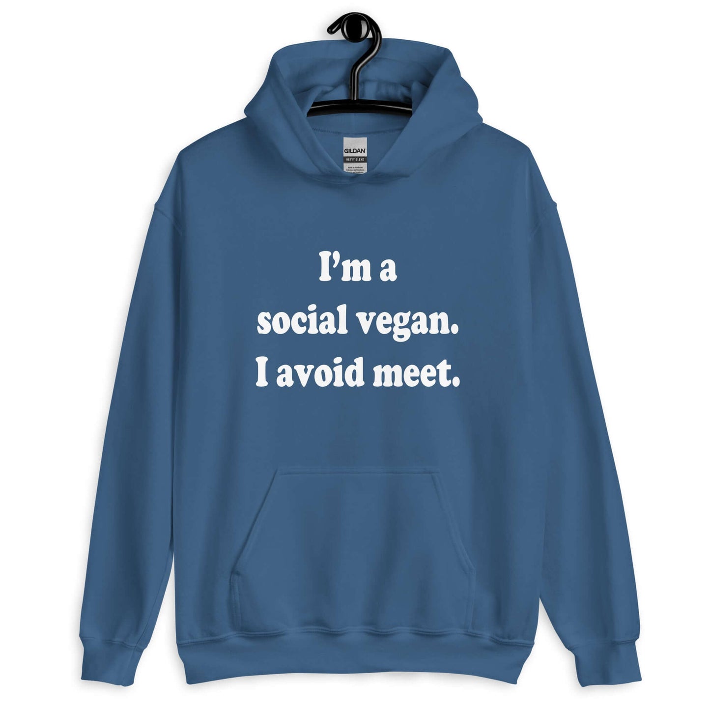 Indigo blue hoodie sweatshirt with the pun phrase I'm a social vegan, I avoid meet printed on the front.