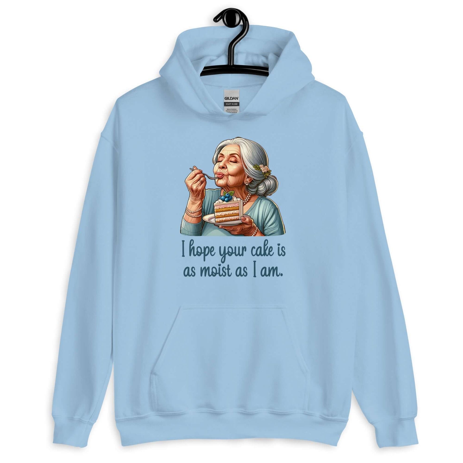 Light blue hoodie with image of grey haired older woman enjoying a bite of a piece of cake with the words I hope your cake is as moist as I am printed on the front.