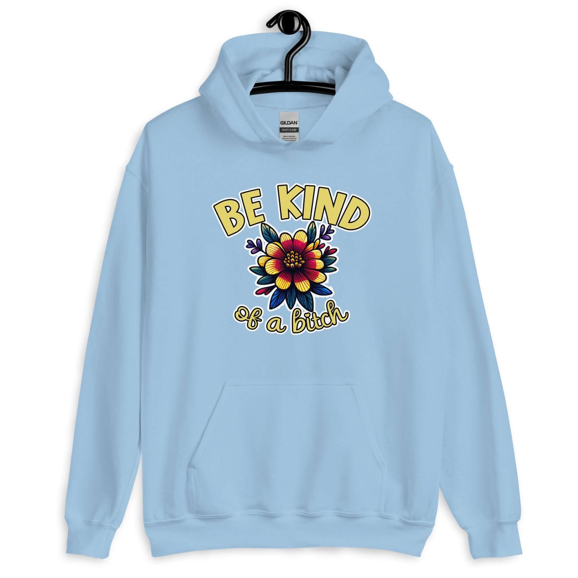 Light blue hoodie sweatshirt with an image of a flower and the words Be kind above the flower in yellow bold block font. The words Of a bitch are smaller in script font under the flower. The design is printed on the front of the hoodie.