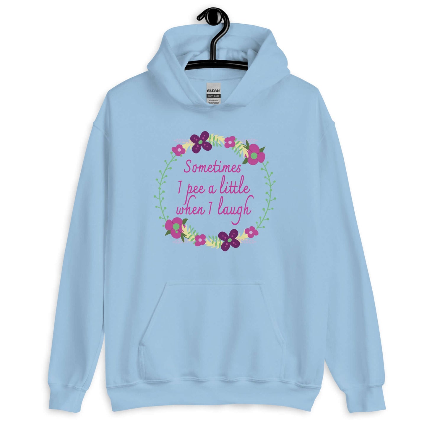 Light blue hoodie sweatshirt that has a minimalistic style line drawing floral wreath with the phrase Sometimes I pee a little when I laugh printed in the center of the wreath. The graphics are printed on the front of the hoodie.