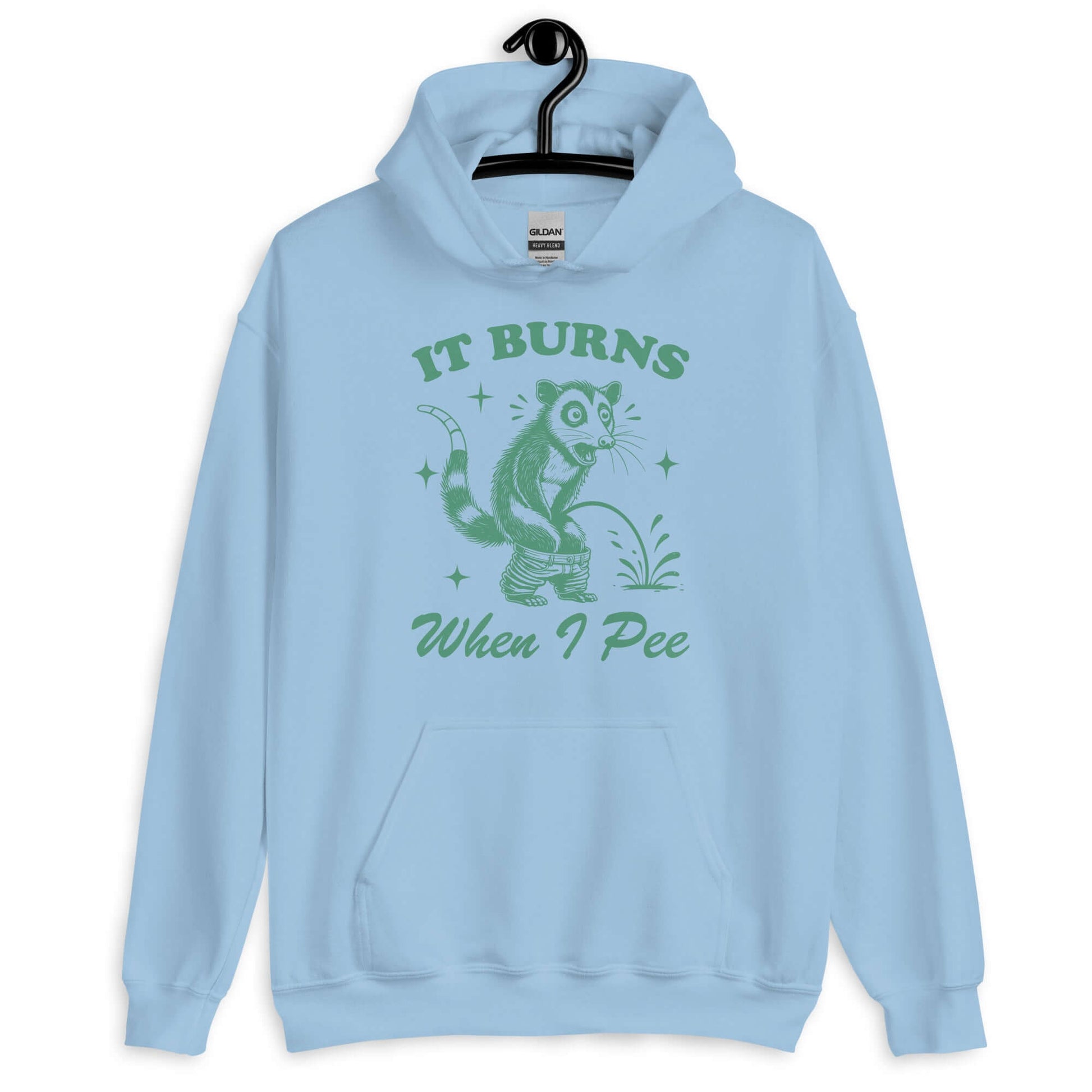 Light blue hoodie sweatshirt that has graphic of an opossum peeing and the words it burns when I pee printed on the front.