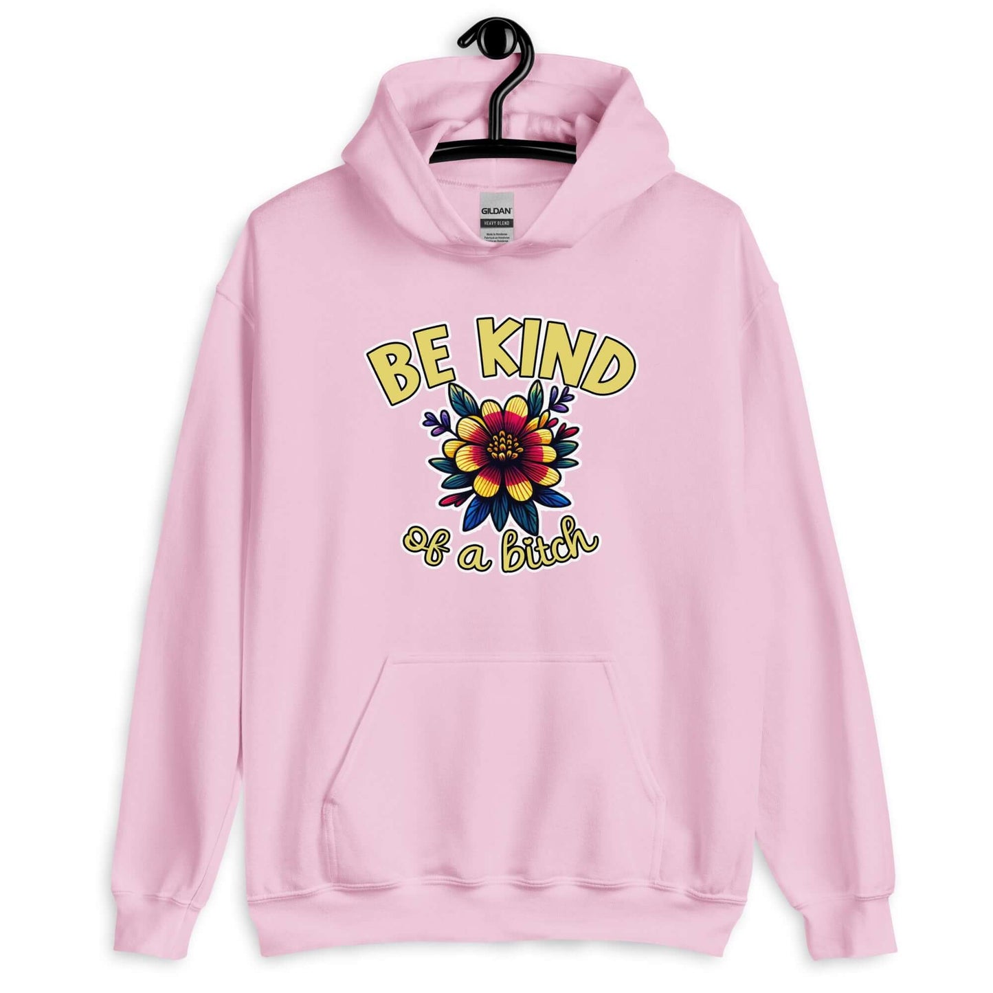 Light pink hoodie sweatshirt with an image of a flower and the words Be kind above the flower in yellow bold block font. The words Of a bitch are smaller in script font under the flower. The design is printed on the front of the hoodie.