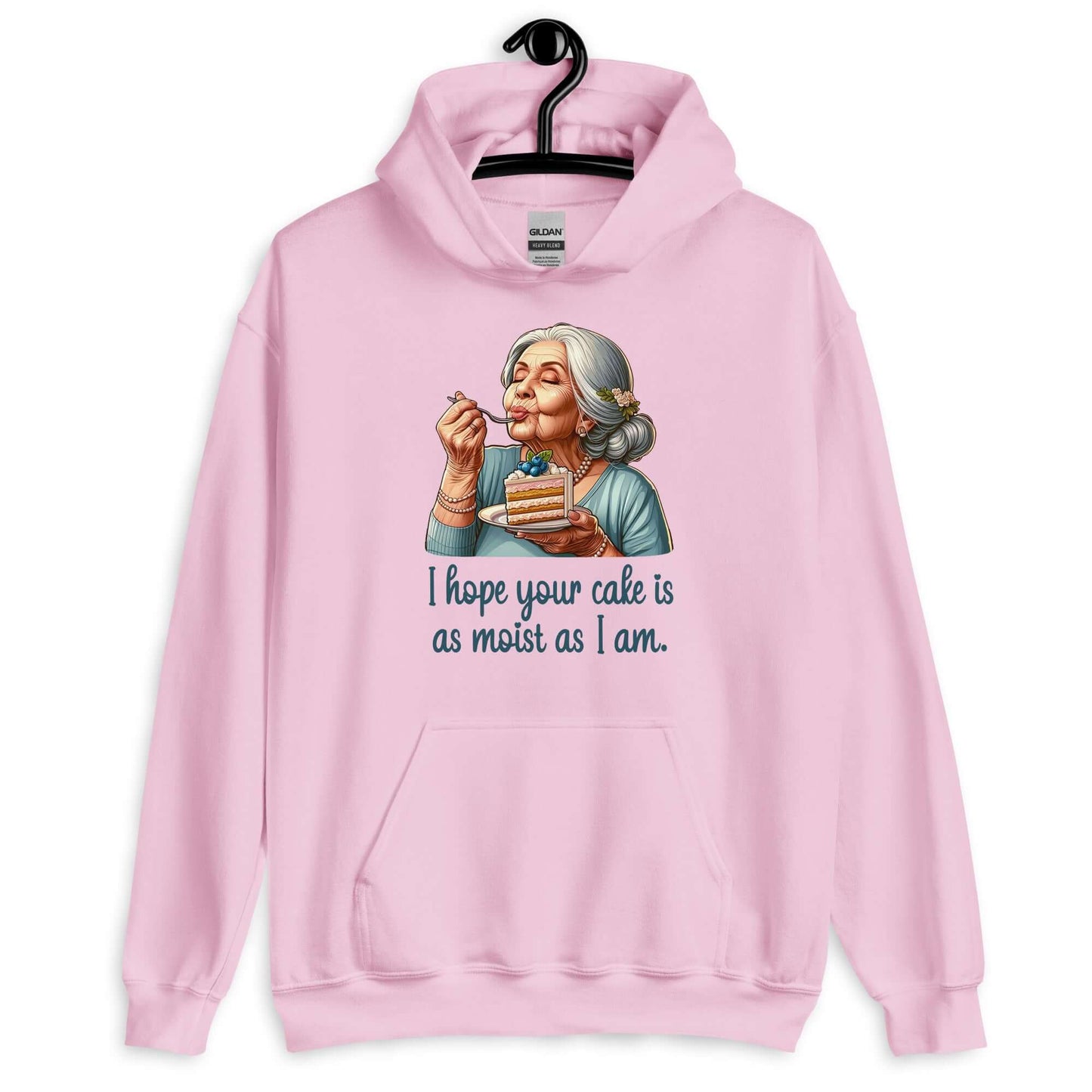 Light pink hoodie with image of grey haired older woman enjoying a bite of a piece of cake with the words I hope your cake is as moist as I am printed on the front.