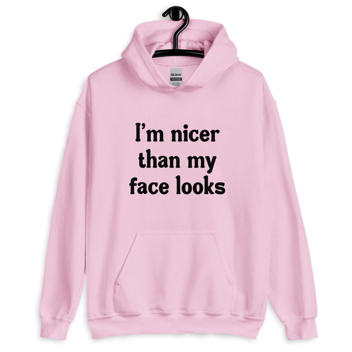 Light pink hoodie sweatshirt with the phrase I'm nicer than my face looks printed on the front.