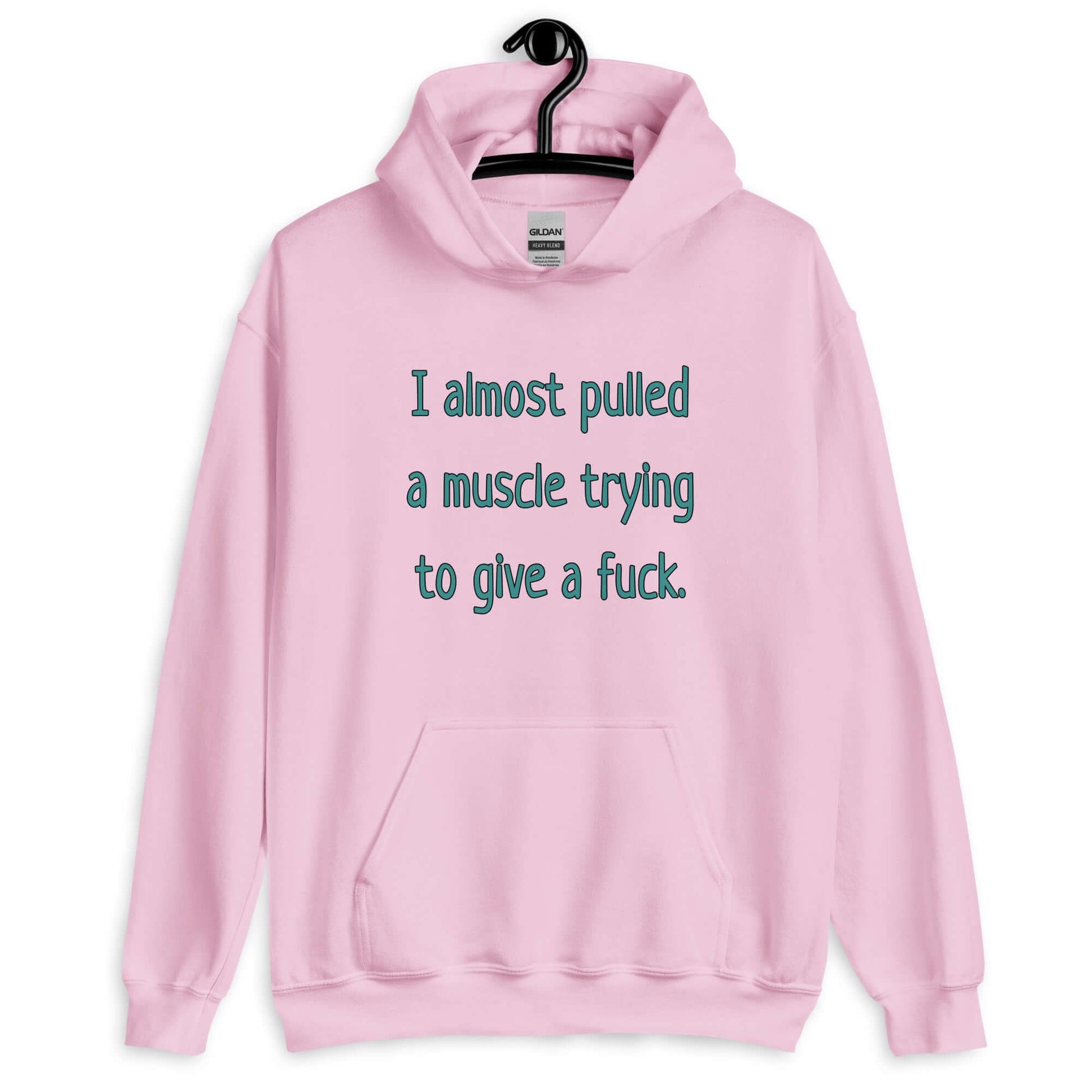 Light pink hoodie sweatshirt with the words I Almost pulled a muscle trying to give a fuck printed on the front.