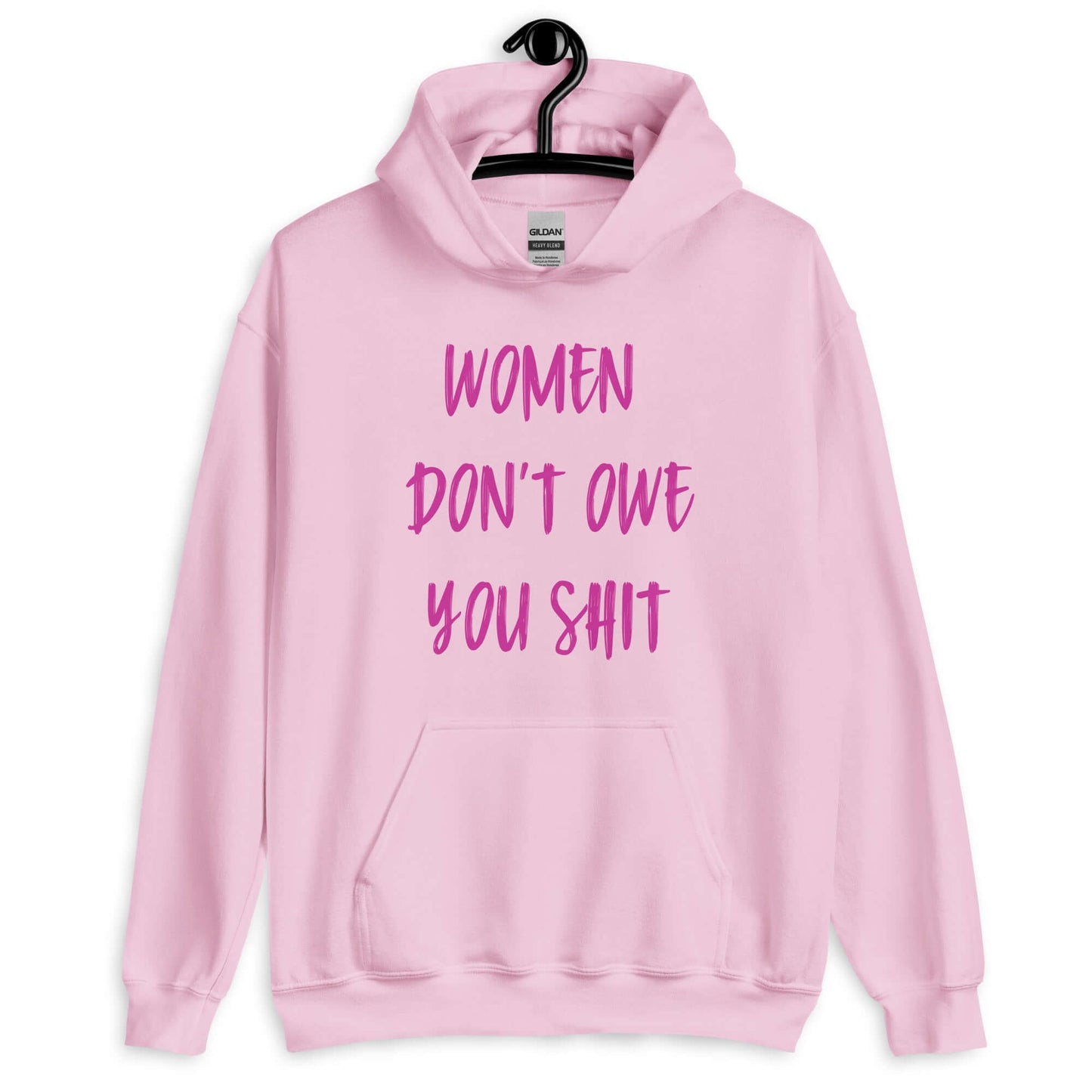 Light pink hoodie sweatshirt with the words Women don't owe you shit printed on the front in pink.