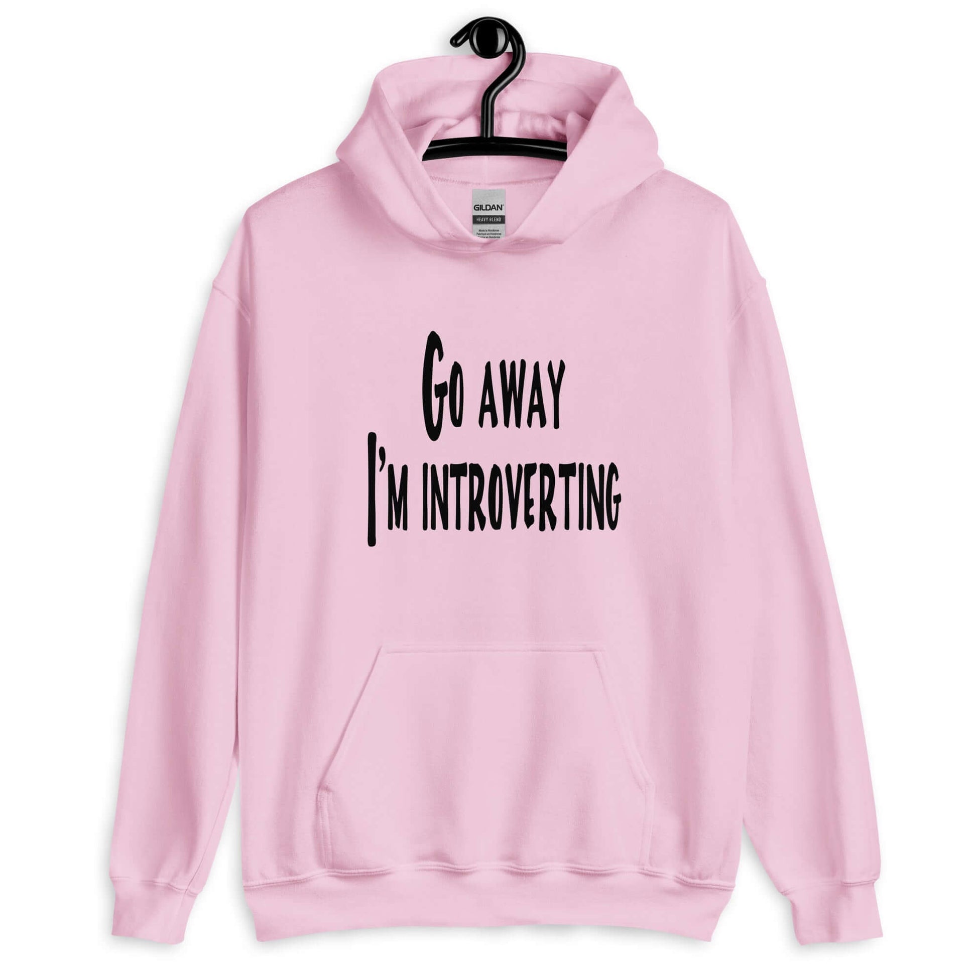 Light pink hoodie sweatshirt with the phrase Go away, I'm introverting printed on the front.