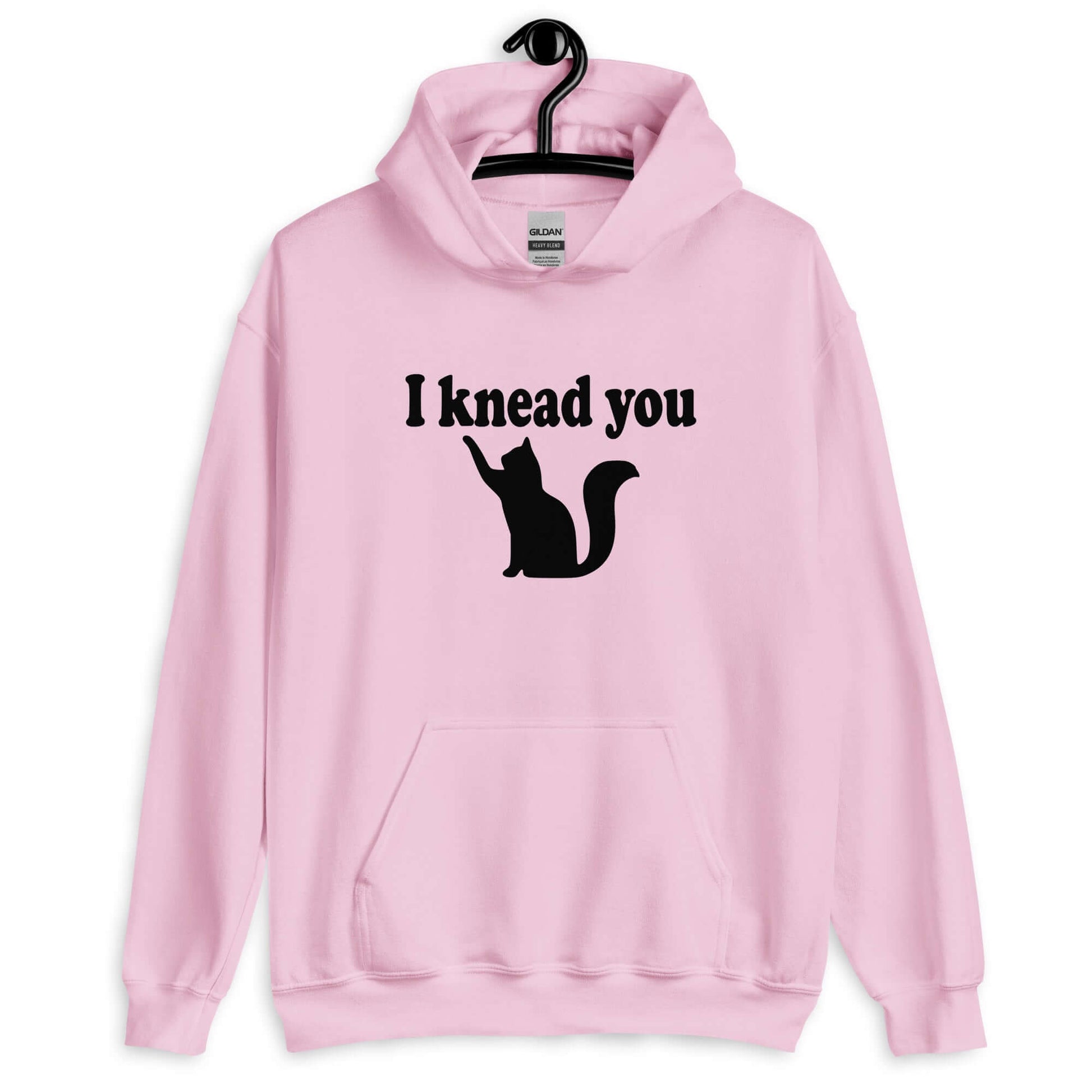 Light pink hoodie sweatshirt that has an image of a silhouette of a cat and the words I knead you printed on the front.