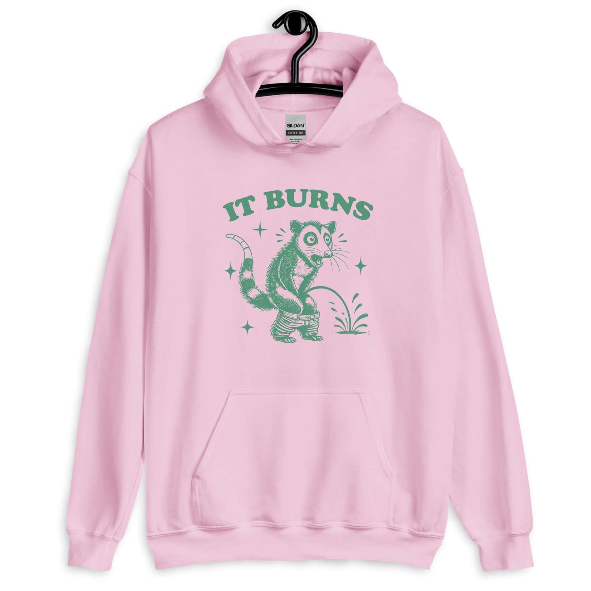 Light pink hoodie sweatshirt with an image of an opossum peeing. The words It burns are printed above.