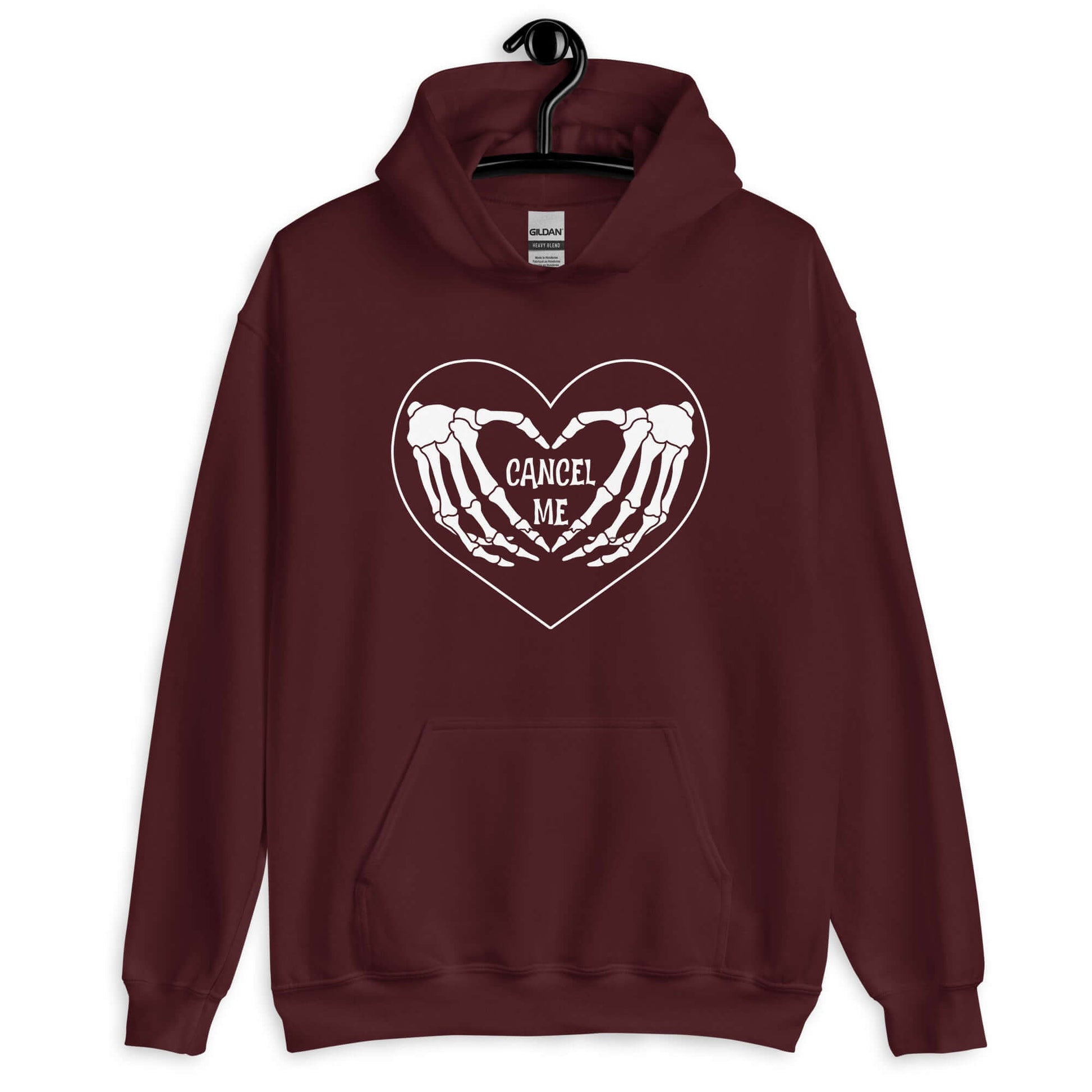 Maroon hoodie sweatshirt with a black heart and skeleton hands making a heart shape printed on the front. The words Cancel Me are inside of the heart.