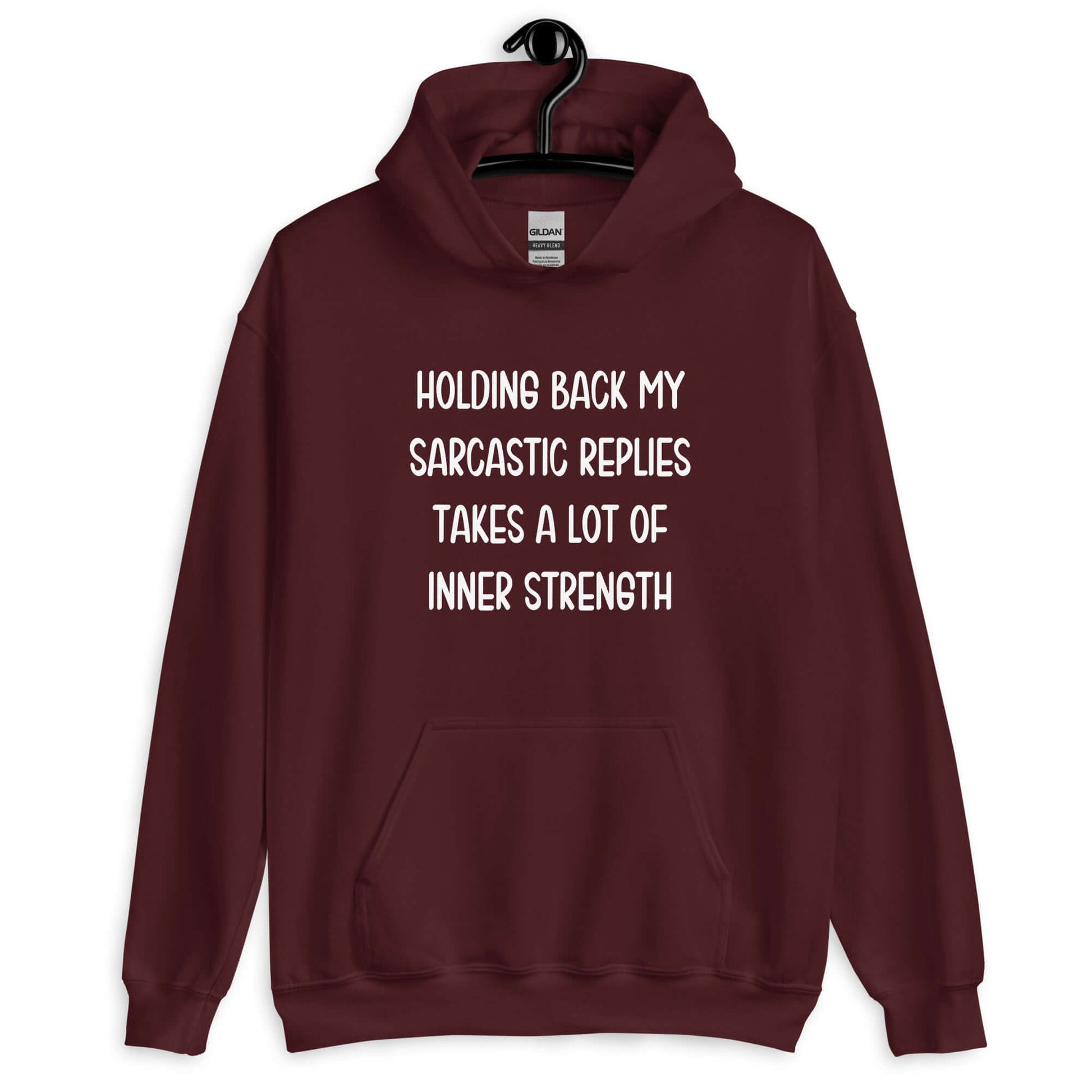 Maroon hoodie sweatshirt with the phrase Holding back my sarcastic replies takes a lot of inner strength printed on the front.