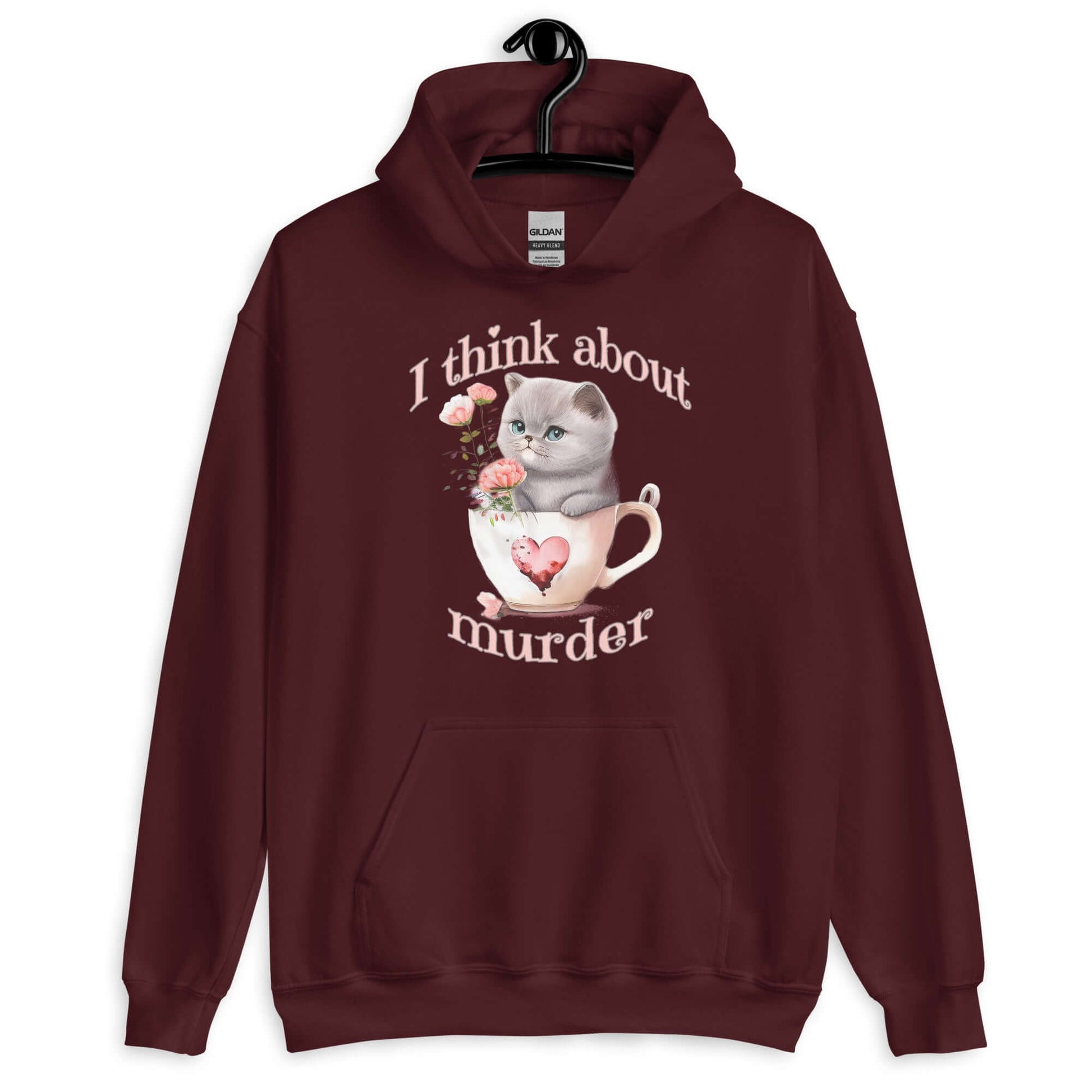 Maroon hoodie sweatshirt that says I think about murder with image of cute fluffy kitten sitting in a teacup printed on the front.