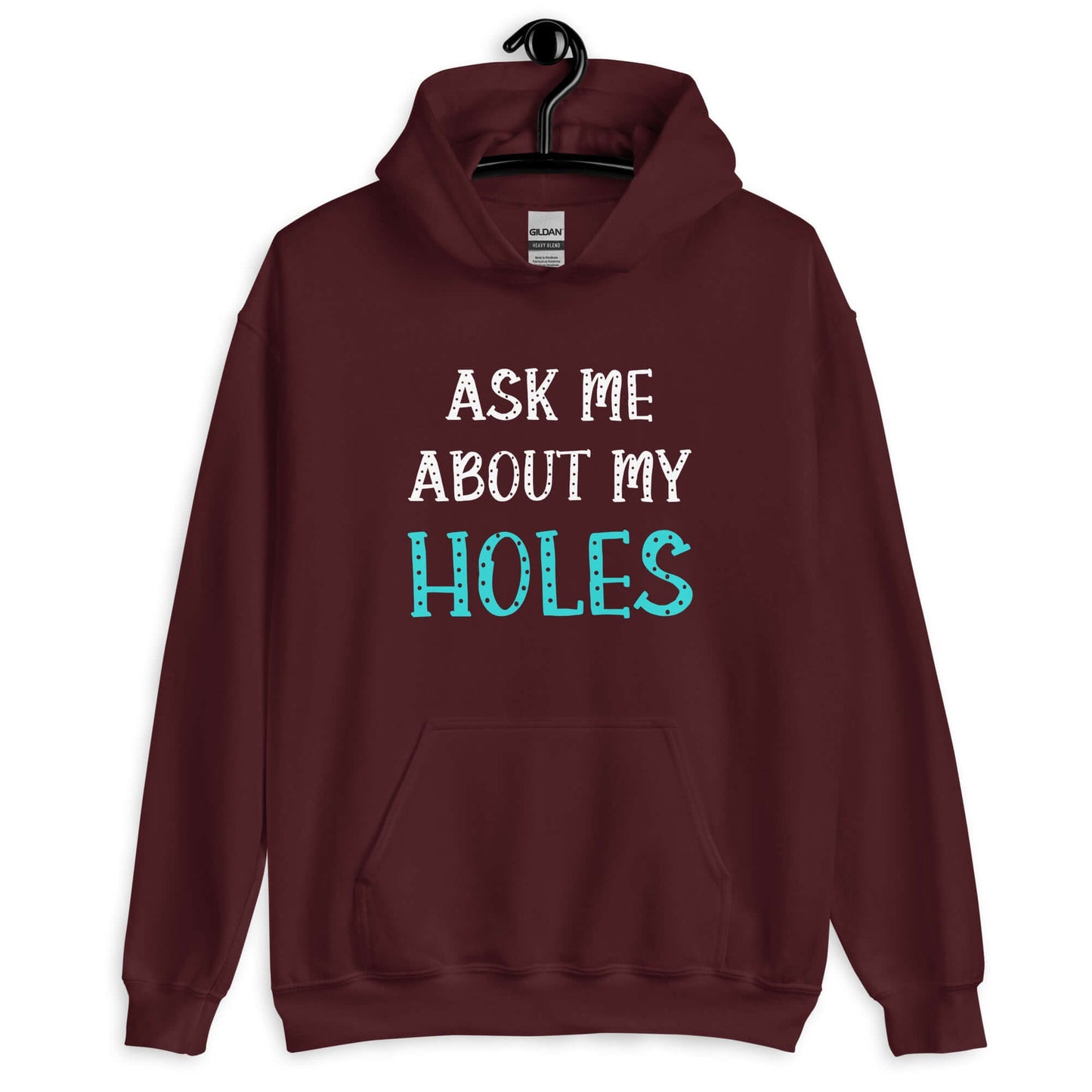 Maroon hoodie sweatshirt with the words Ask me about my holes printed on the front. The word holes in turquoise color and the rest of the text is white.