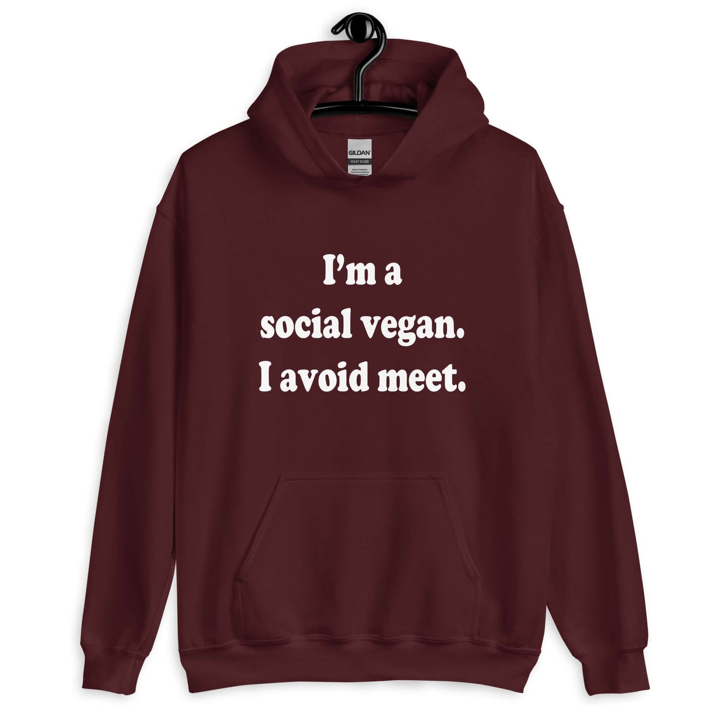 Maroon hoodie sweatshirt with the pun phrase I'm a social vegan, I avoid meet printed on the front.