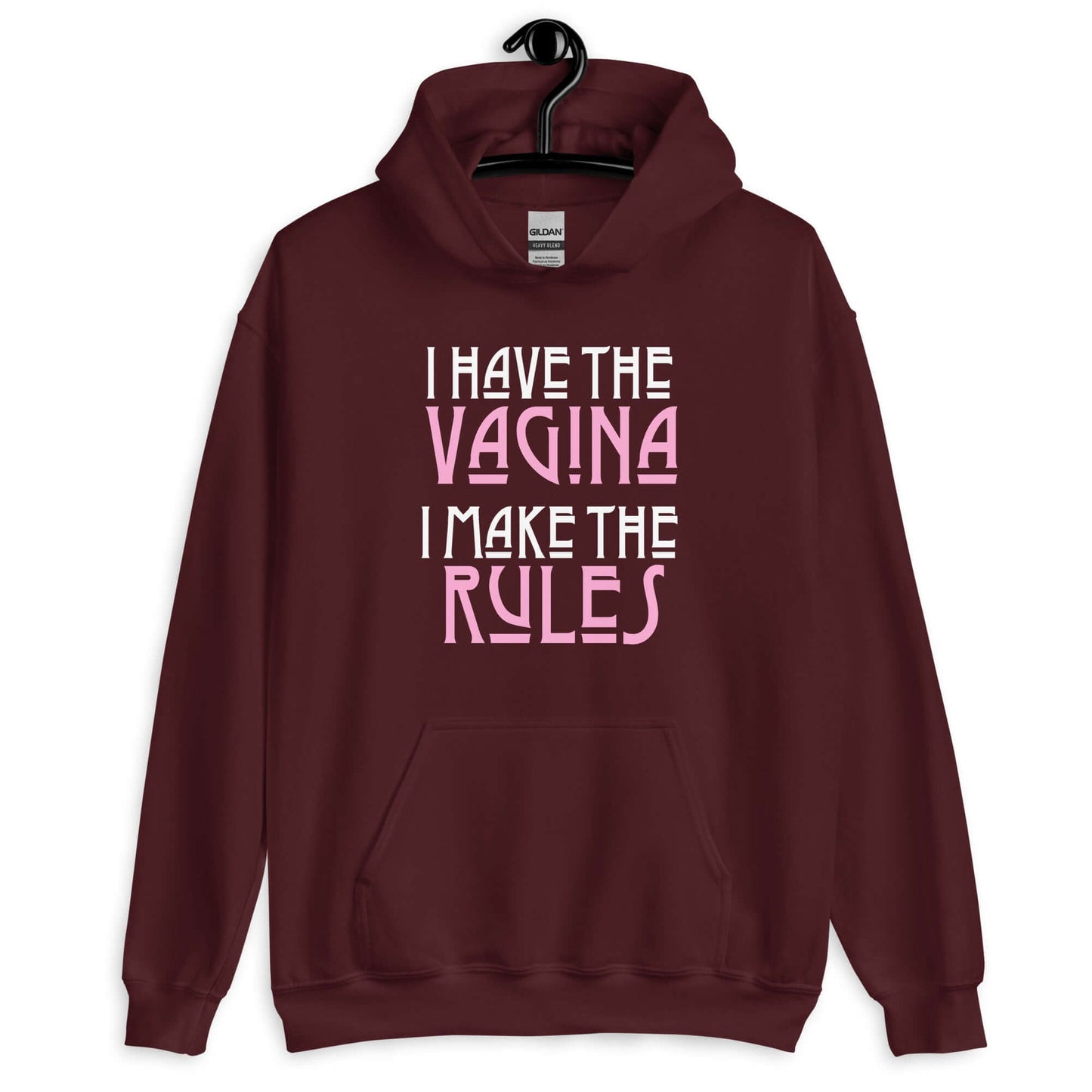 Maroon hoodie sweatshirt with the words I have the vagina , I make the rules printed on the front. The words vagina and rules are pink, the rest of the words are white.