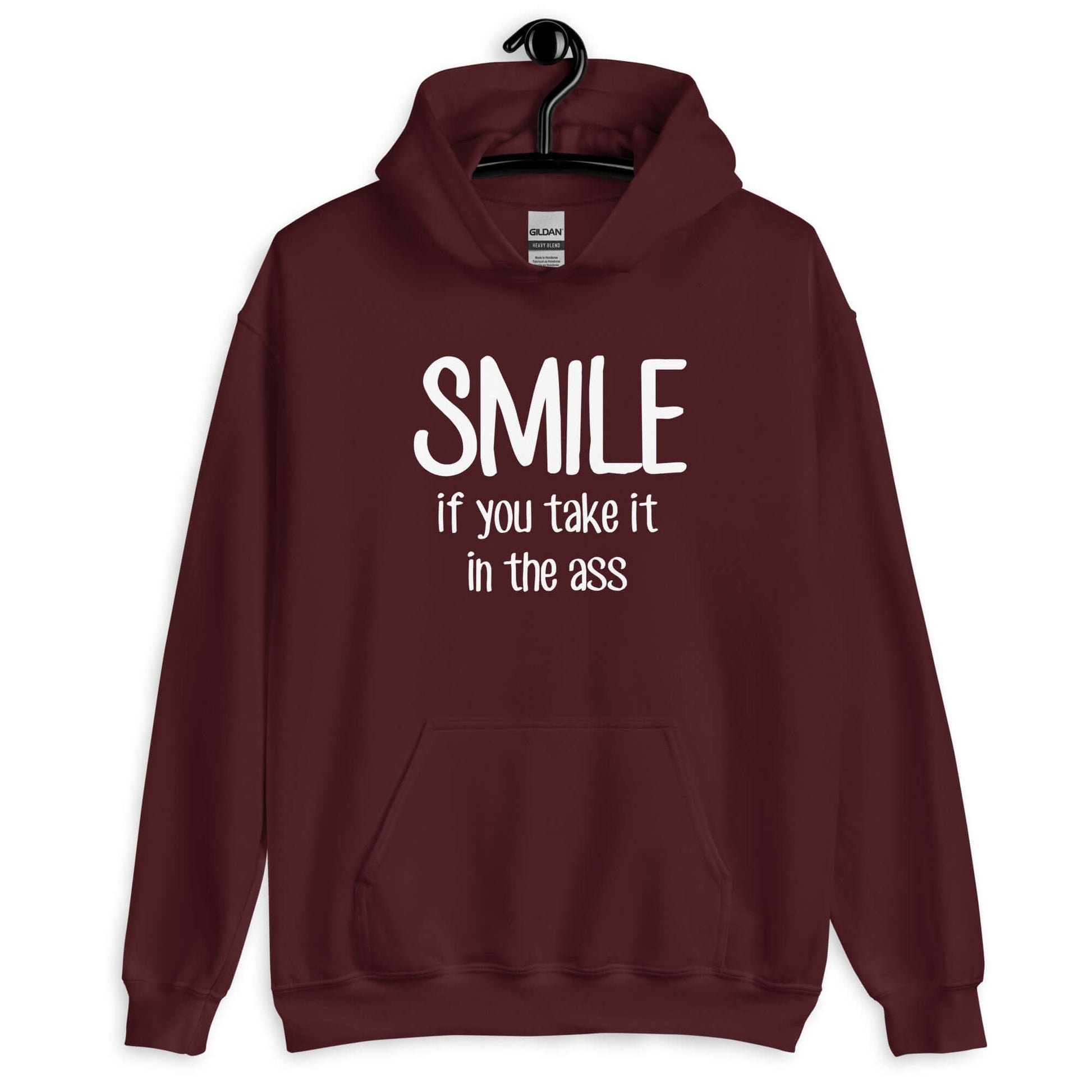 Maroon hoodie sweatshirt with the phrase Smile if you take it in the ass printed on the front. The word smile is large and the words take it in the ass are much smaller.