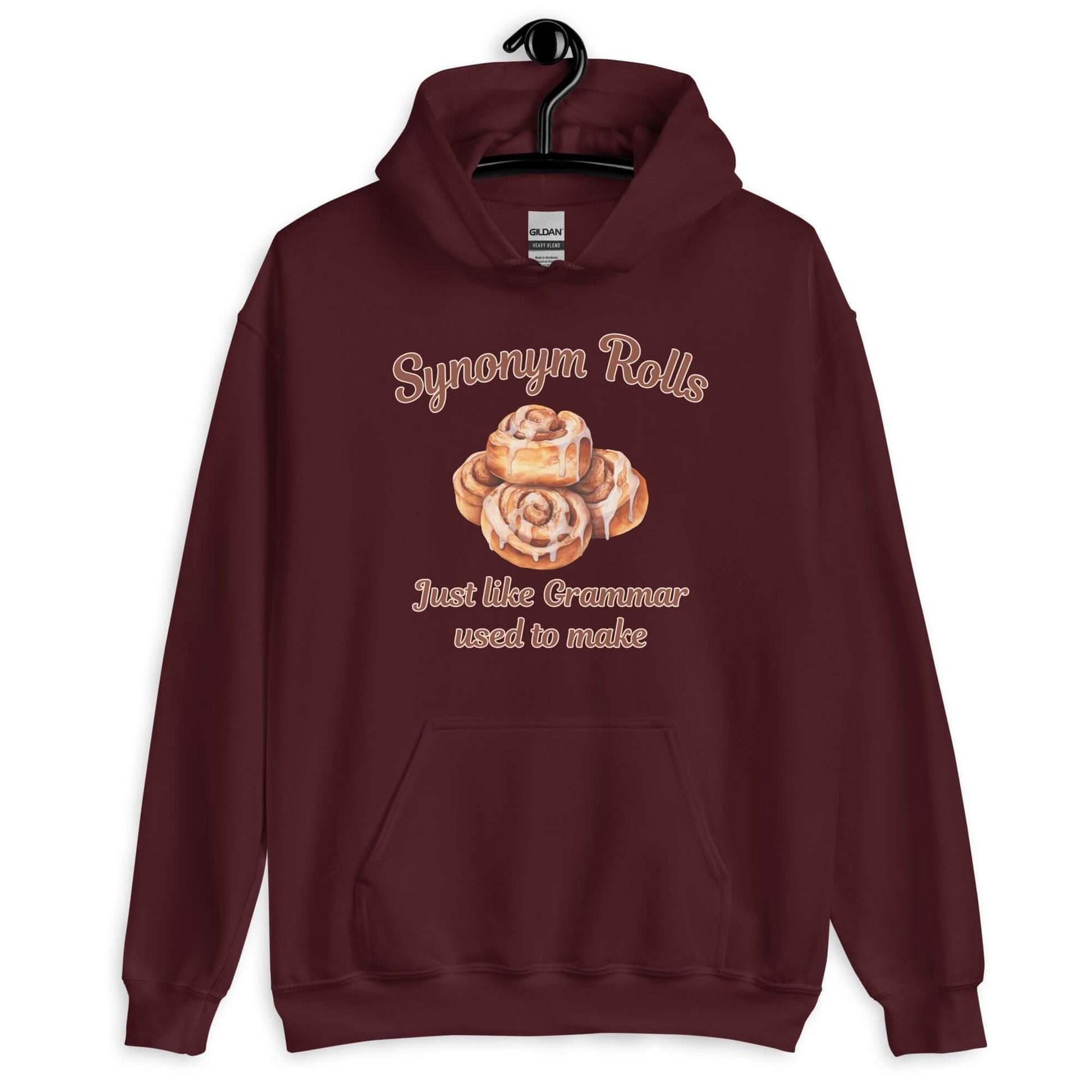 Maroon hoodie sweatshirt with an image of cinnamon rolls and the pun phrase Synonym rolls Just like Grammar used to make printed on the front.