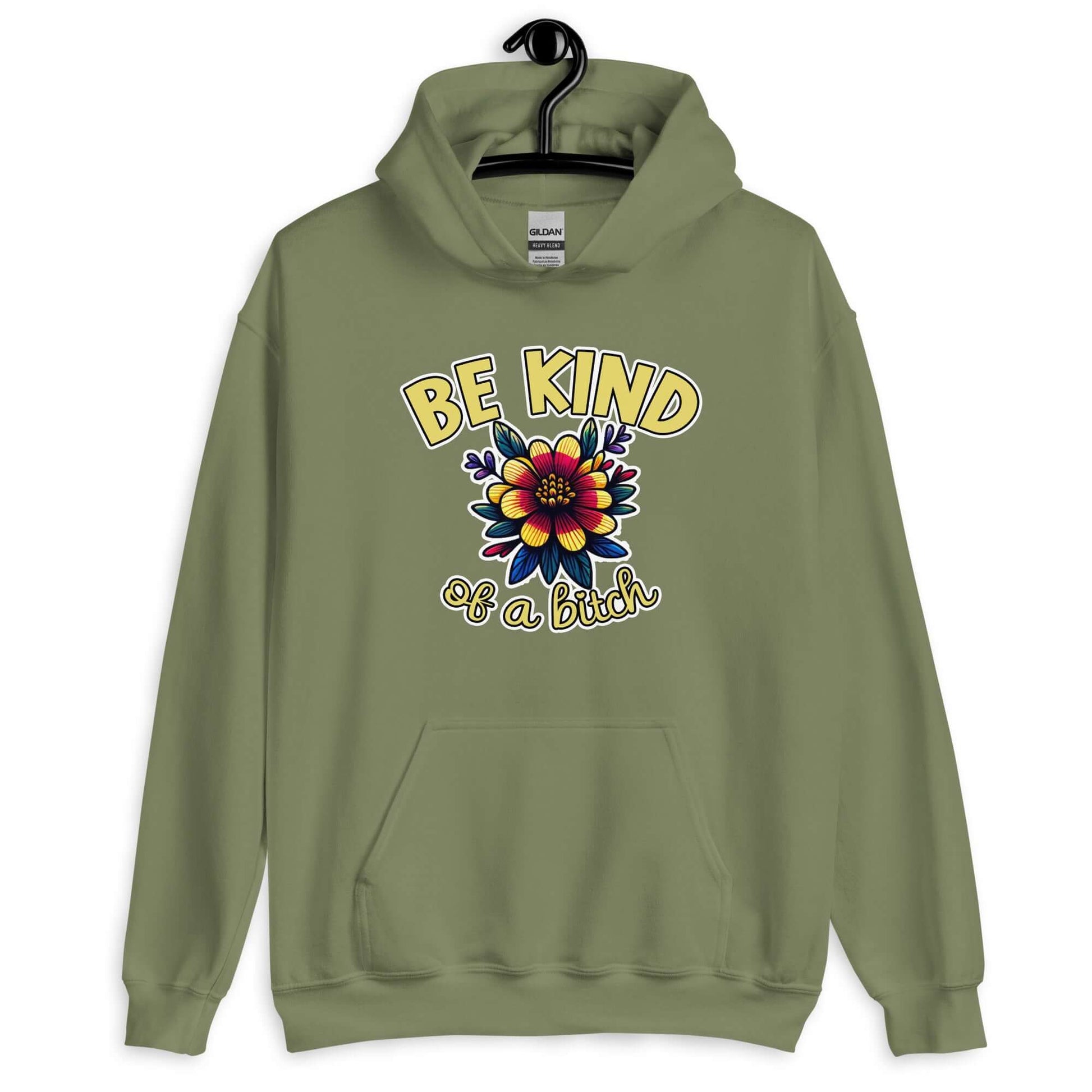 Military green hoodie sweatshirt with an image of a flower and the words Be kind above the flower in yellow bold block font. The words Of a bitch are smaller in script font under the flower. The design is printed on the front of the hoodie.