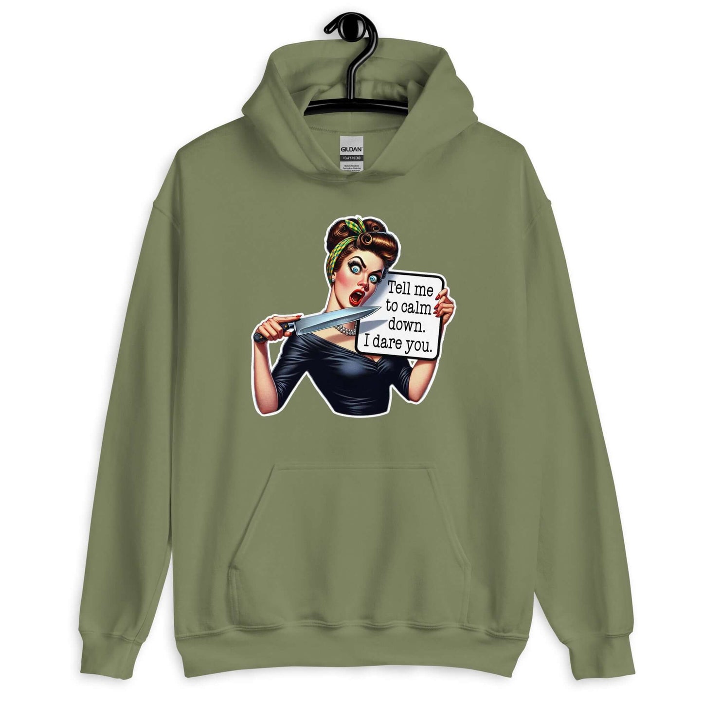 Military green hooded sweatshirt displayed on a hanger. The sweatshirt has a graphic of an angry looking retro woman holding a knife and a sign. The sign says Tell me to calm down I dare you. The graphic is printed on the front of the hoodie.