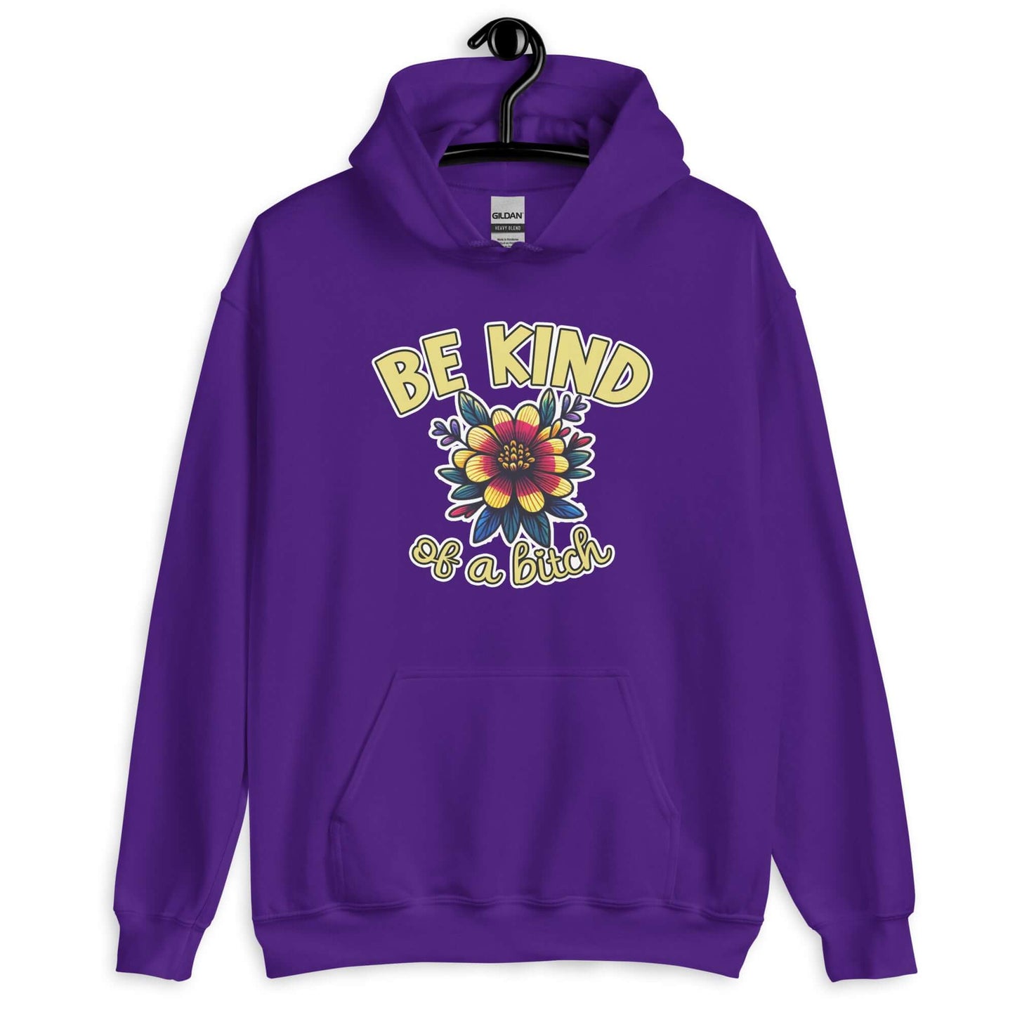 Purple hoodie sweatshirt with an image of a flower and the words Be kind above the flower in yellow bold block font. The words Of a bitch are smaller in script font under the flower. The design is printed on the front of the hoodie.