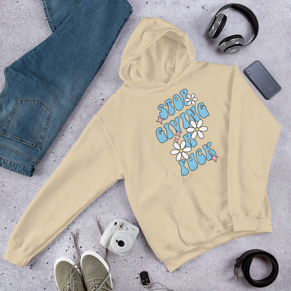 Sand color hoodie sweatshirt with stop giving a fuck printed on the front.