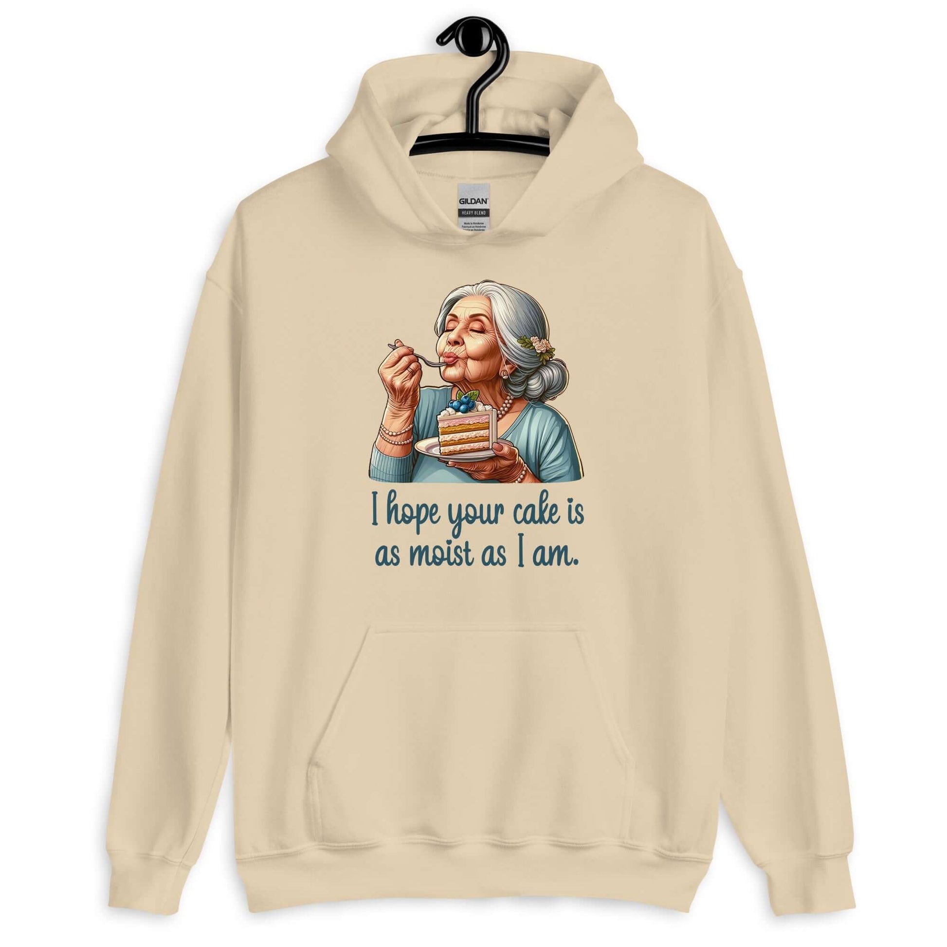 Sand hoodie sweatshirt with image of grey haired older woman enjoying a bite of a piece of cake with the words I hope your cake is as moist as I am printed on the front.