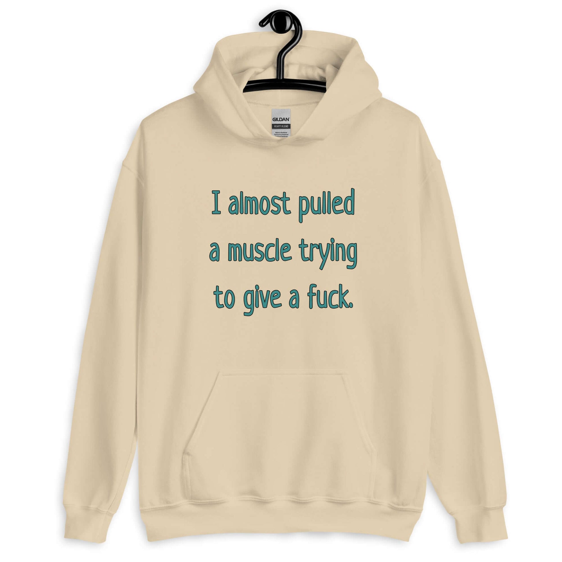 Sand color hoodie sweatshirt with the words I Almost pulled a muscle trying to give a fuck printed on the front.